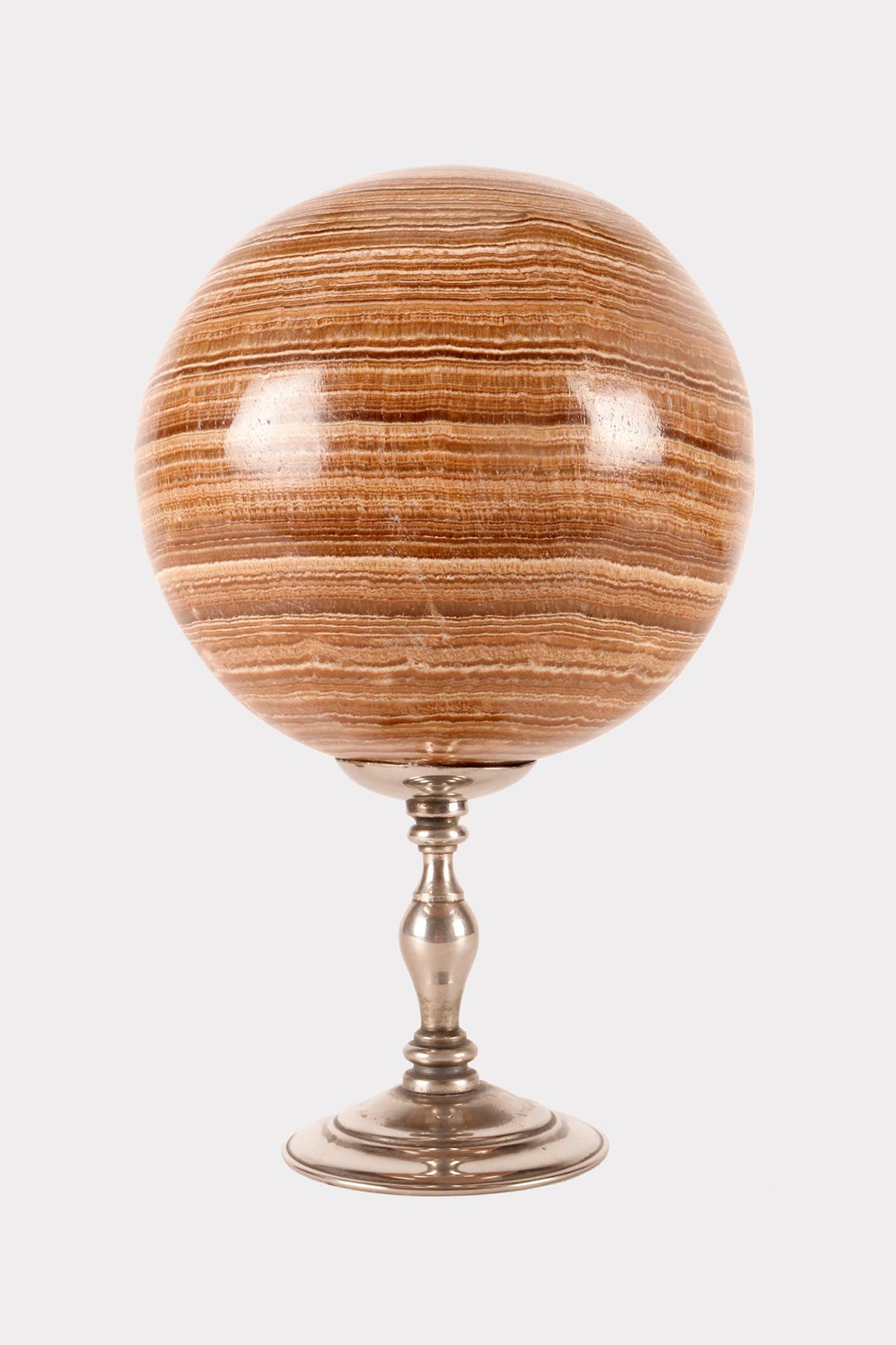 A large sphere of Aragonite stone, resting on a base, made of silver which has a cup-shaped stand with a wavy profile that opens upwards with a concave surface. Italy circa 1870.