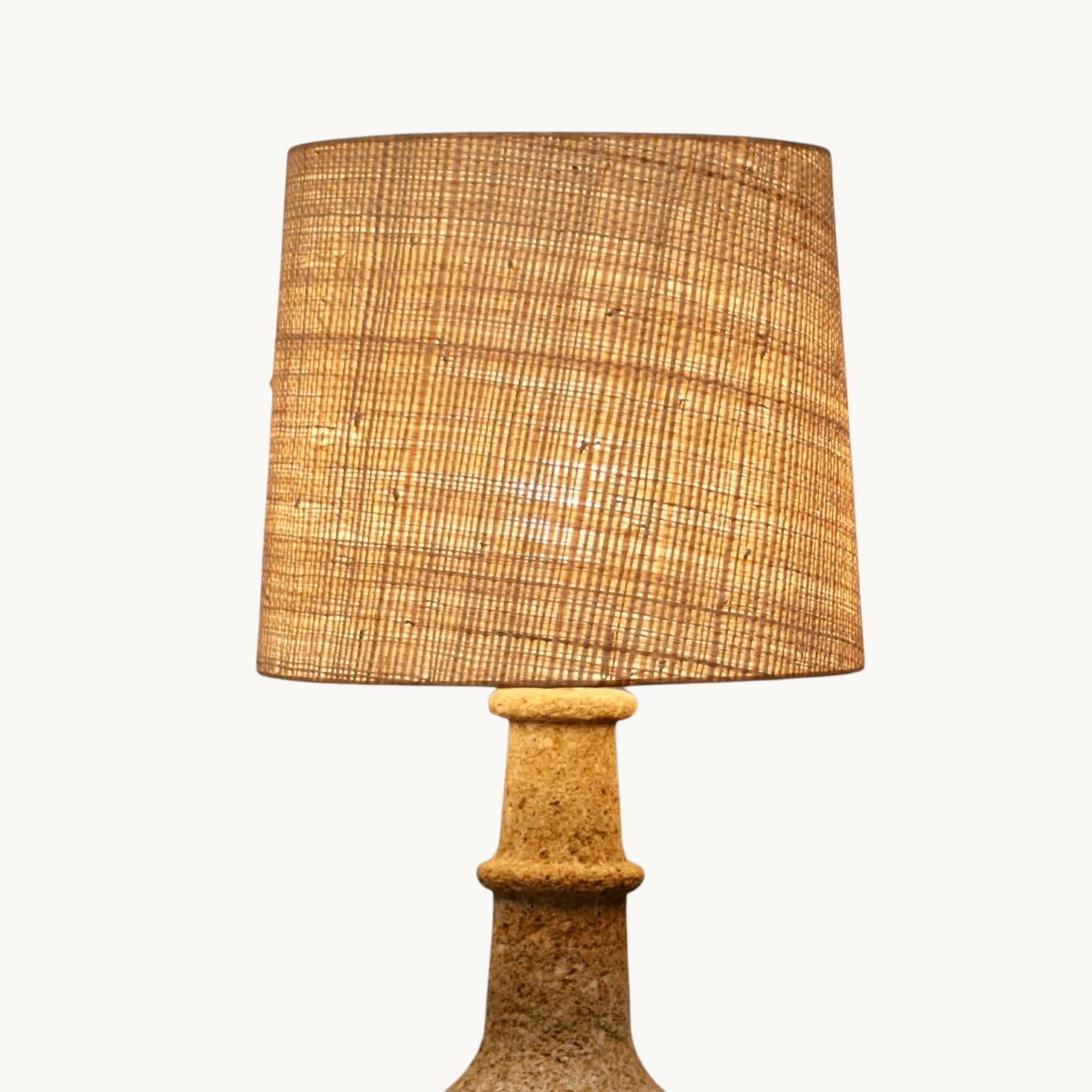 Eine große balusterförmige Lampe aus rekonstituiertem Stein und ihr Schirm aus Bast. Frankreich, 60er Jahre.