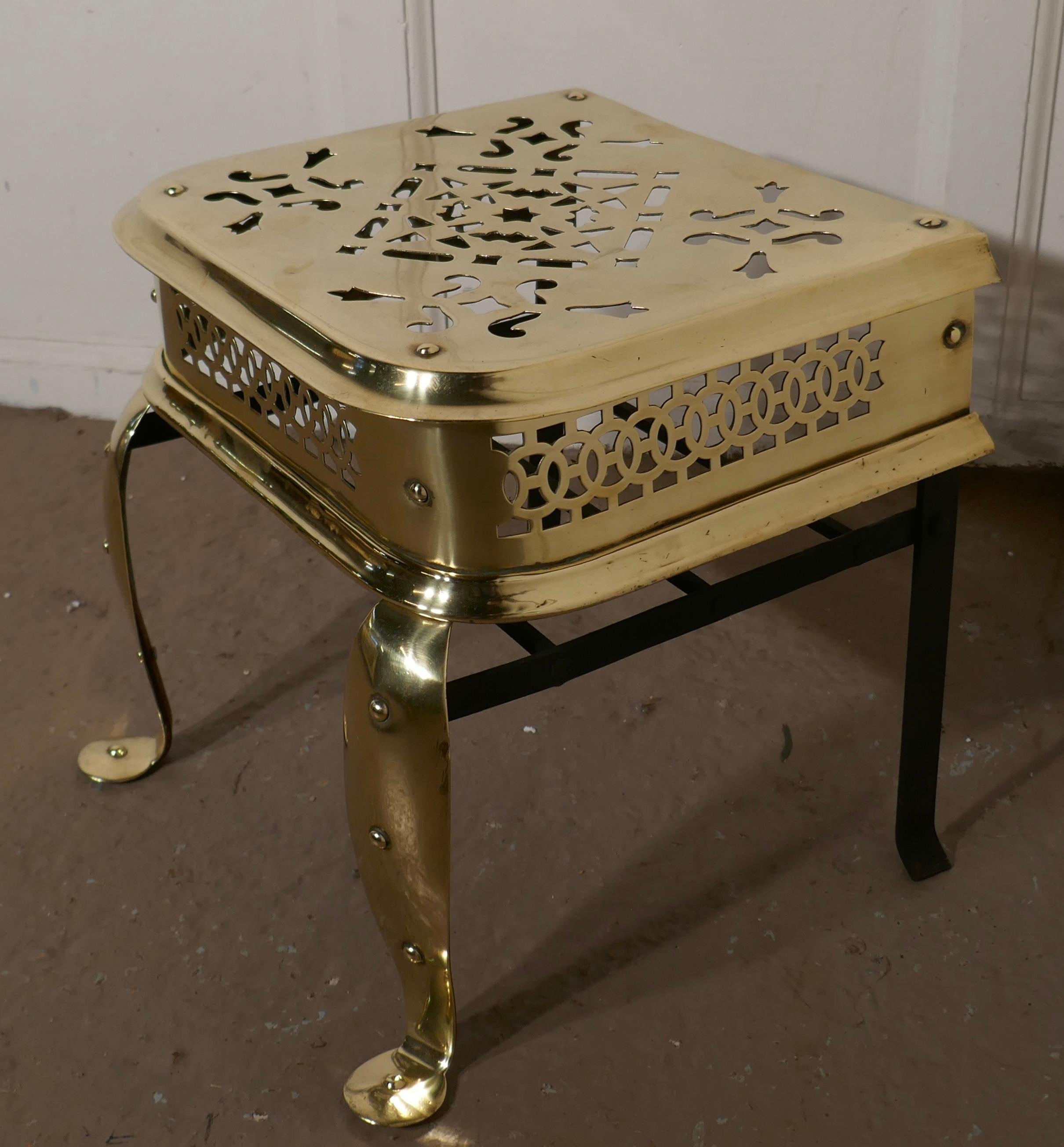 A large sturdy Georgian footman, Kettle Trivet

A large brass footman, with beautiful pierced decoration, the footman stands on big cabriole legs at the front and would look superb by an inglenook fire.
The footman is in very good condition and