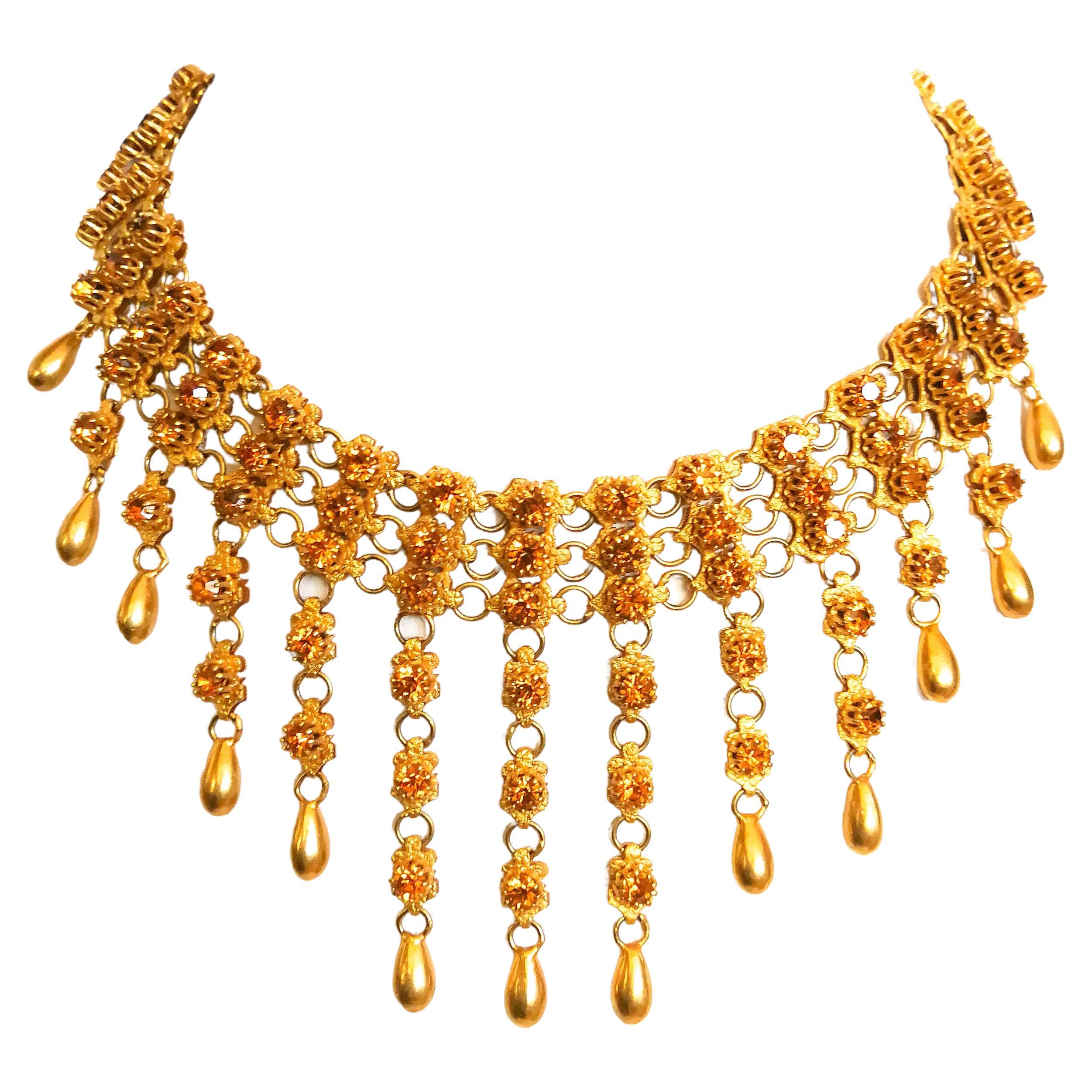 An outstanding and highly unusual necklace and matching earrings, made by Mitchel Maer for Christian Dior. Clear bright topaz coloured pastes are set in softly gilded metal to create a magnificent 'festoon style ' necklace, each 'drop' tipped with a