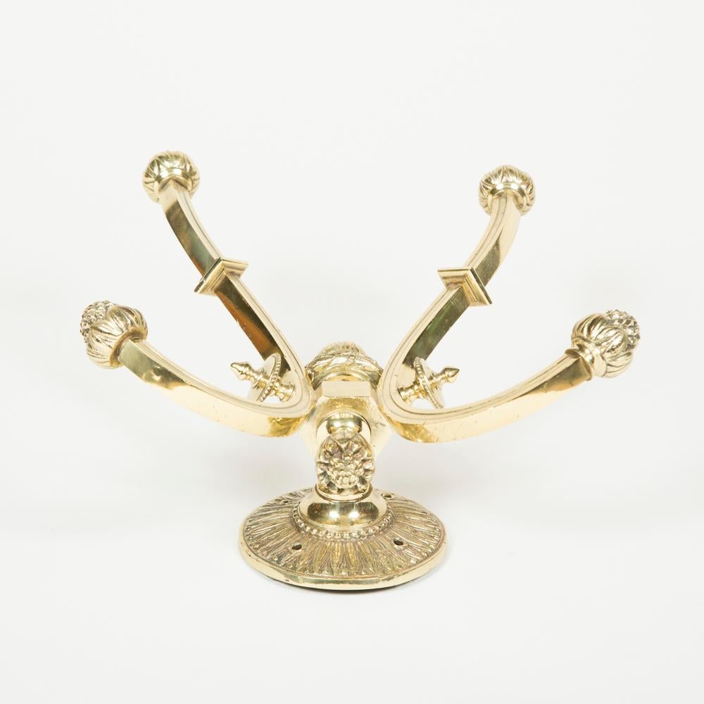 A Edwardian twin arm brass hat and coat hook, with pineapple finials and reeded circular backplate, in the Regency style.

Weight: 1.8 kg.
