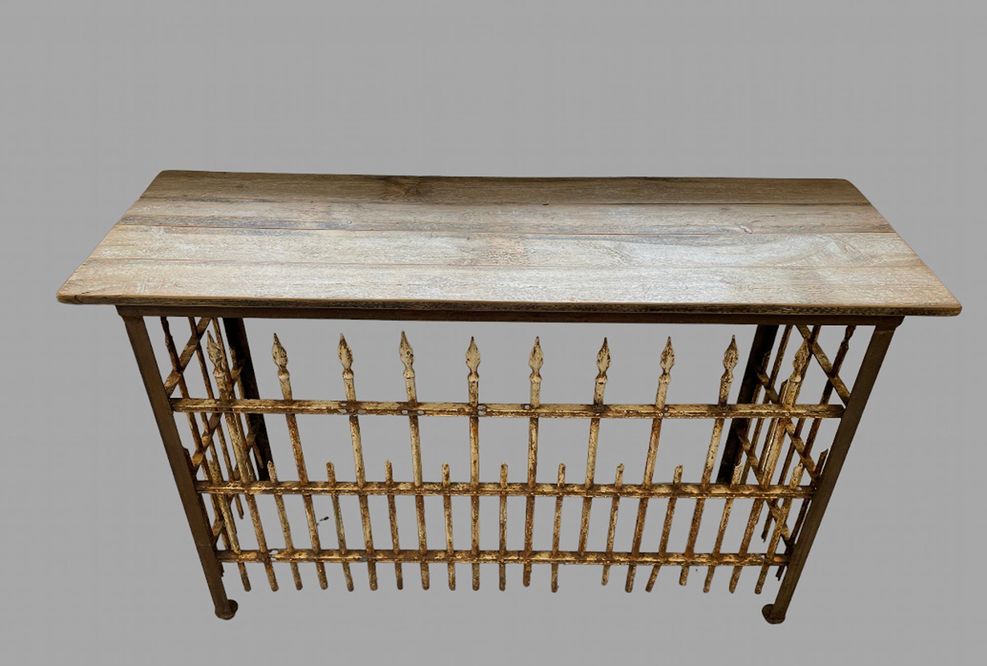 An interesting and unusual wrought iron railing console table. The Railings probably c1930's in distressed state with top of early 20thc wooden Planks. Should a prospect purchaser wish the distressed railings painted black/white this can done.