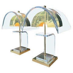 A large unusual pair of 1980s lucite and brass lamps with curved lucite shades