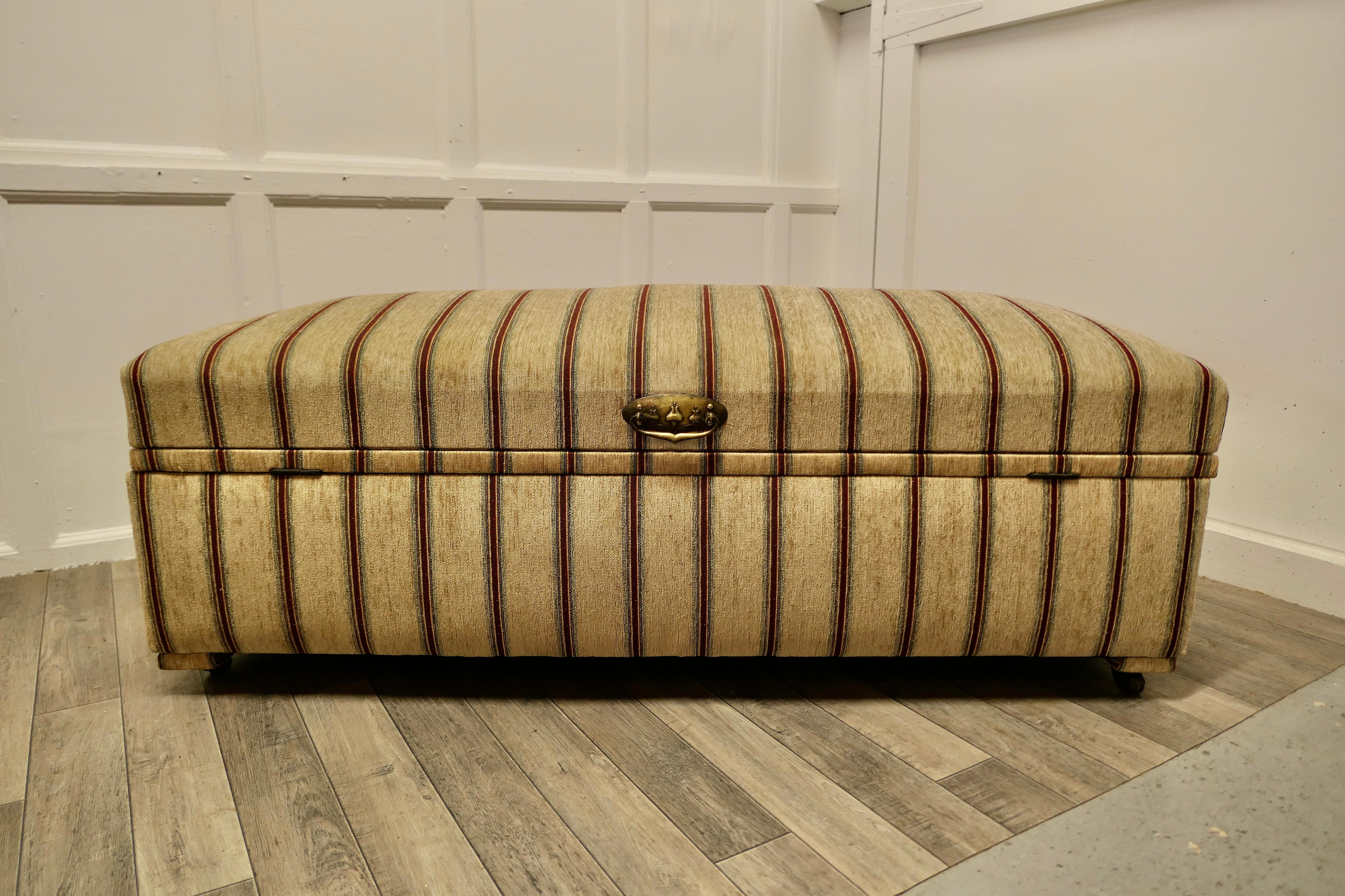 A large upholstered double ottoman or window seat.

This is a very unusual design, the ottoman has been designed to be central in a room as it can open easily from either side, it has a double action hinged top.
A very attractive piece with new