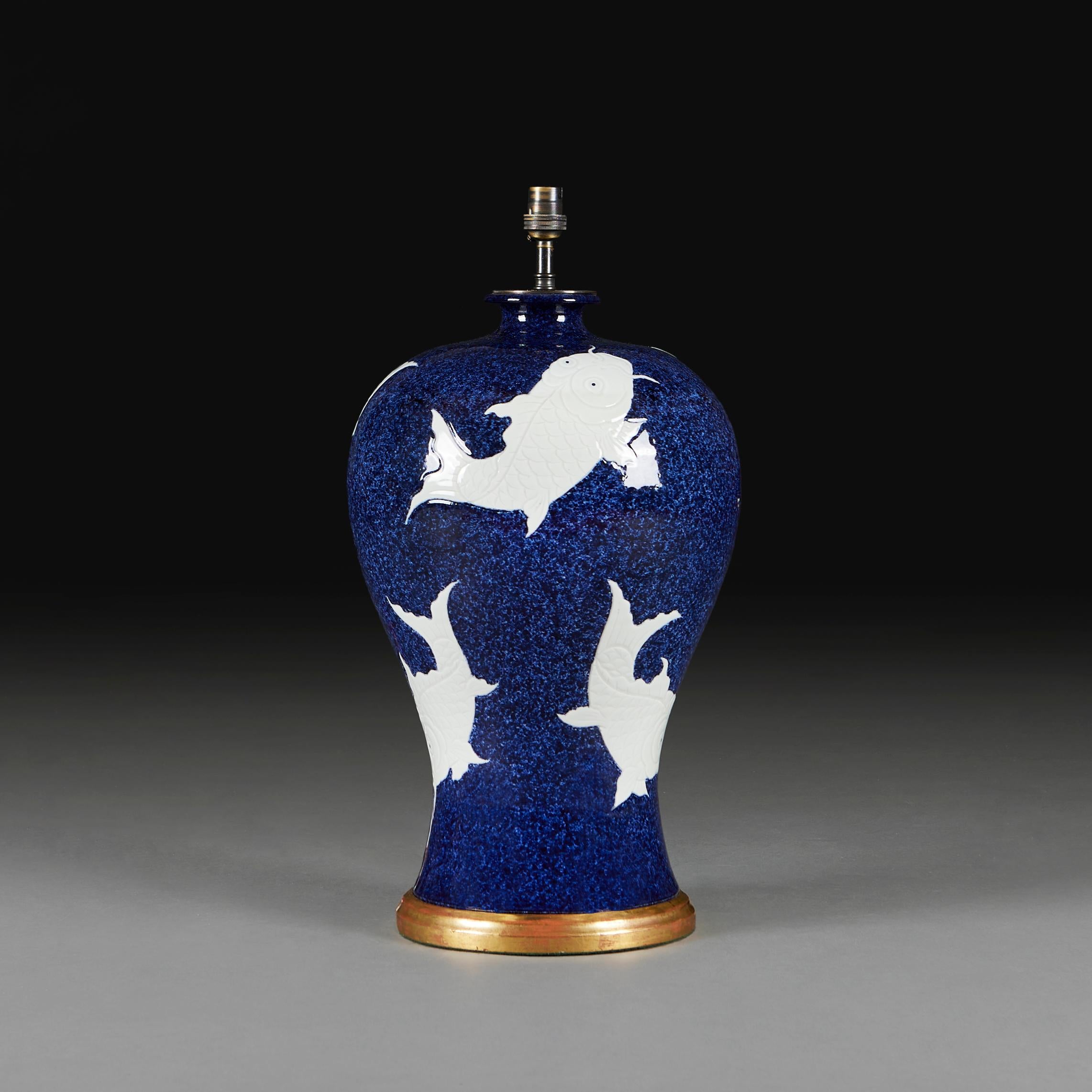 A large early 20th century baluster vase, the background decorated with dark blue glaze, the body decorated with a series of swimming carp, now mounted as a lamp.

Please note:

Lampshade not included. Lamp photographed with a 20” diameter pale