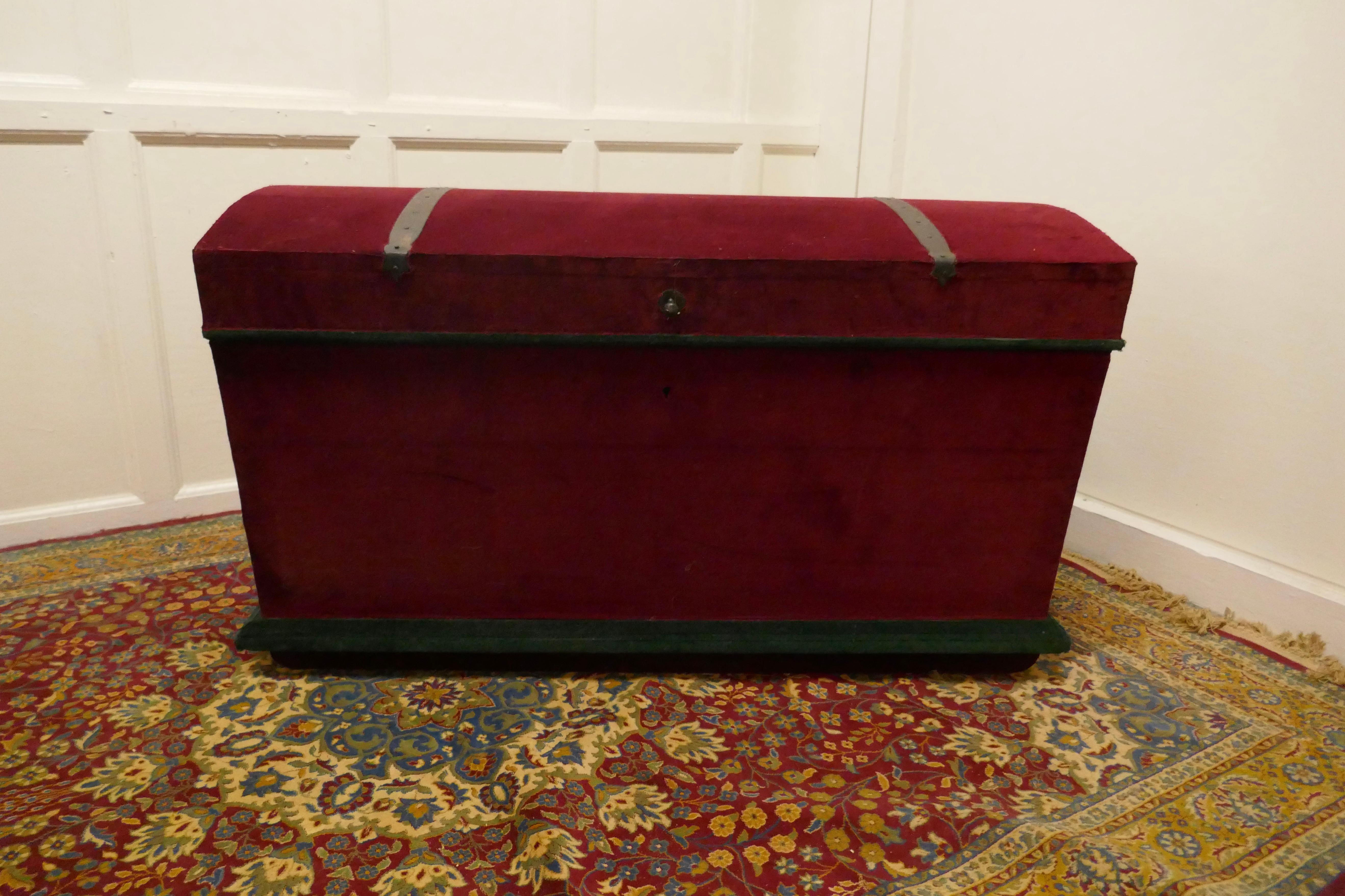 A Large Velvet Banded Dome Top Chest  

The chest is made in heavy quality pine, it is upholstered in wine coloured red velvet, this has been done so that the iron banding and carrying handles still show. The interior has also been lined in the same