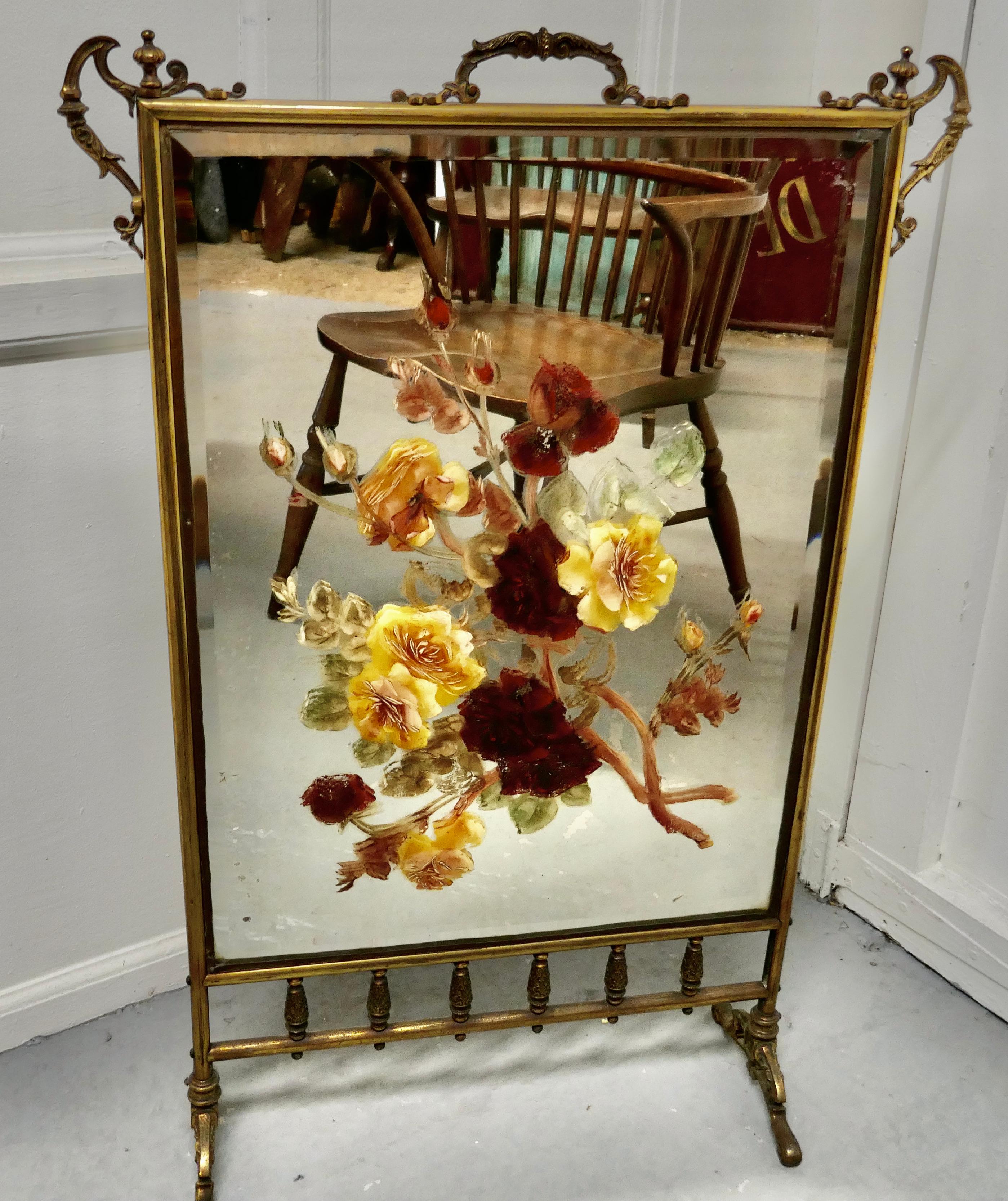 A large Victorian brass and roses painted mirror fire screen

This is a most decorative Fire Screen it has a brass Stand, the Mirror is painted with large colourful Roses.
The screen is in good sound condition, and a very attractive piece if