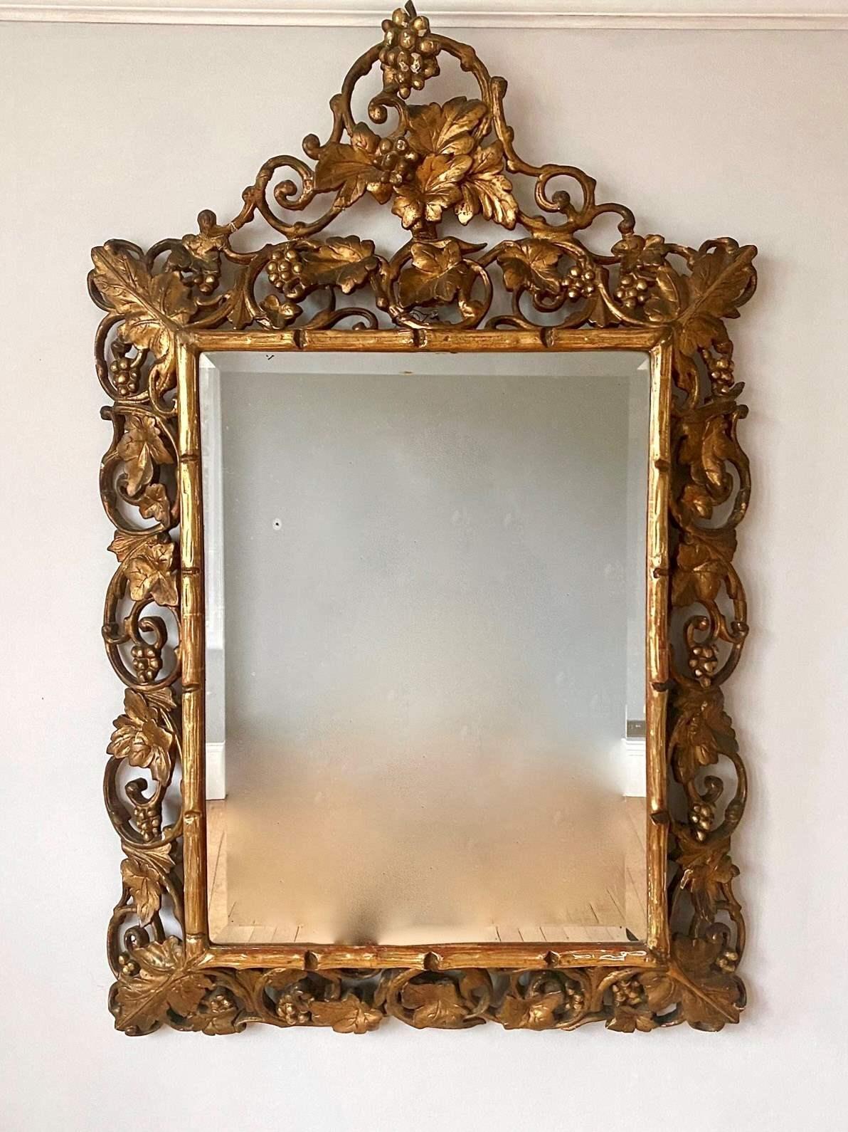 A Large Victorian Carved Giltwood and Gesso Rectangular Wall Mirror. The beautiful deep set cushion frame with inset faux bois to its inner and vine leaf and grapes to its outer. Large mirror with bevelled edge. Small amount of age related foxing in