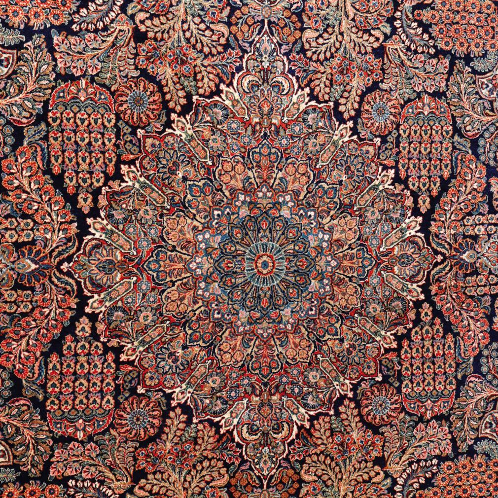 Un grand tapis sarouk persan vintage. Un fin velours de laine noué à la main en nœud persan, étroitement tissé sur une base de coton. Un motif floral et feuillu composé d'un médaillon central rond à cinq niveaux sur un champ bleu foncé densément