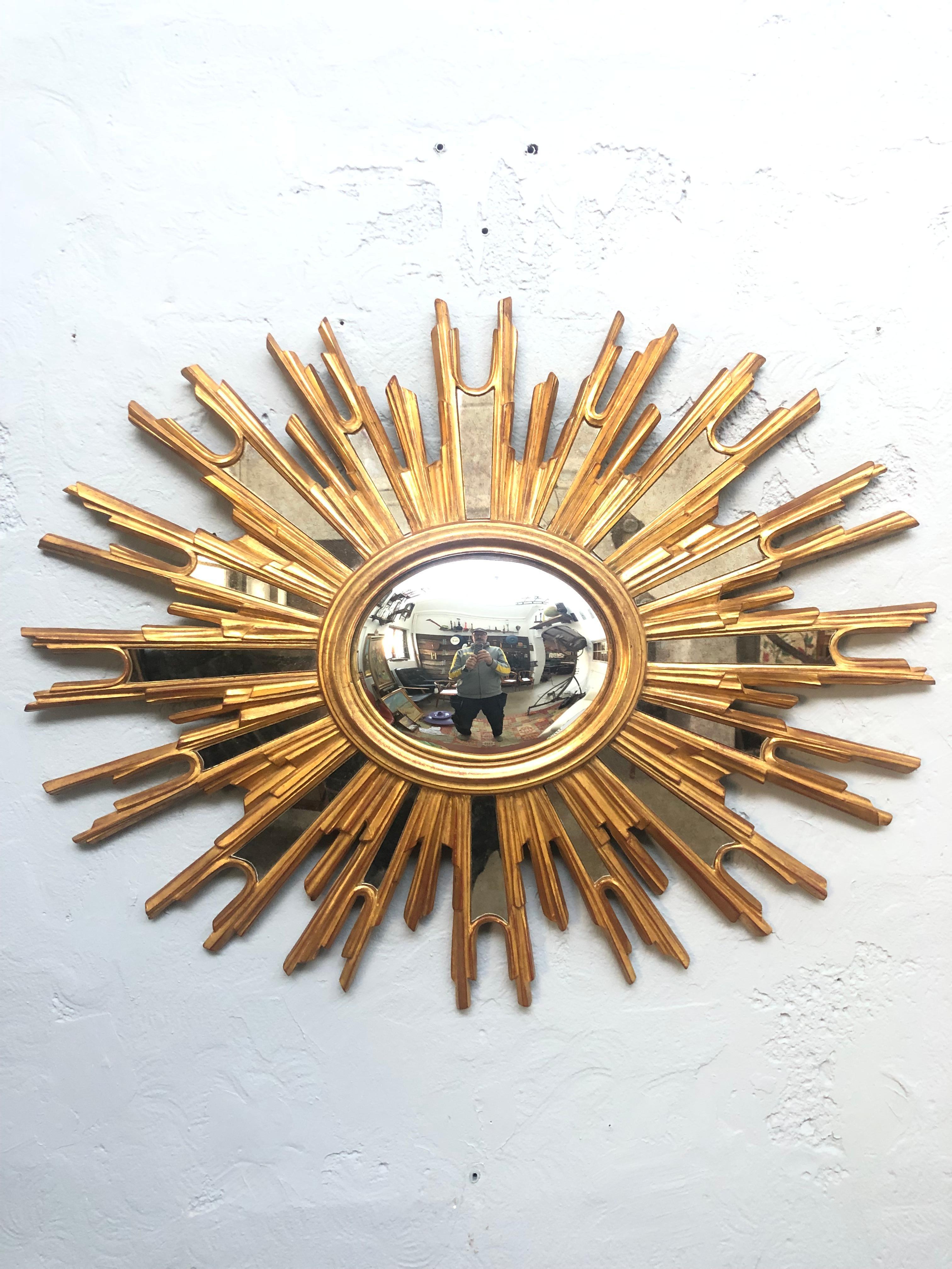 A large sunburst mirror in giltwood by Ateliers Armand Dutry of Belgium and suppliers to the Royal Court. 
In great vintage condition with only slight signs of age related wear. 
Some fading to the makers mark on the reverse side. 
16 pieces of