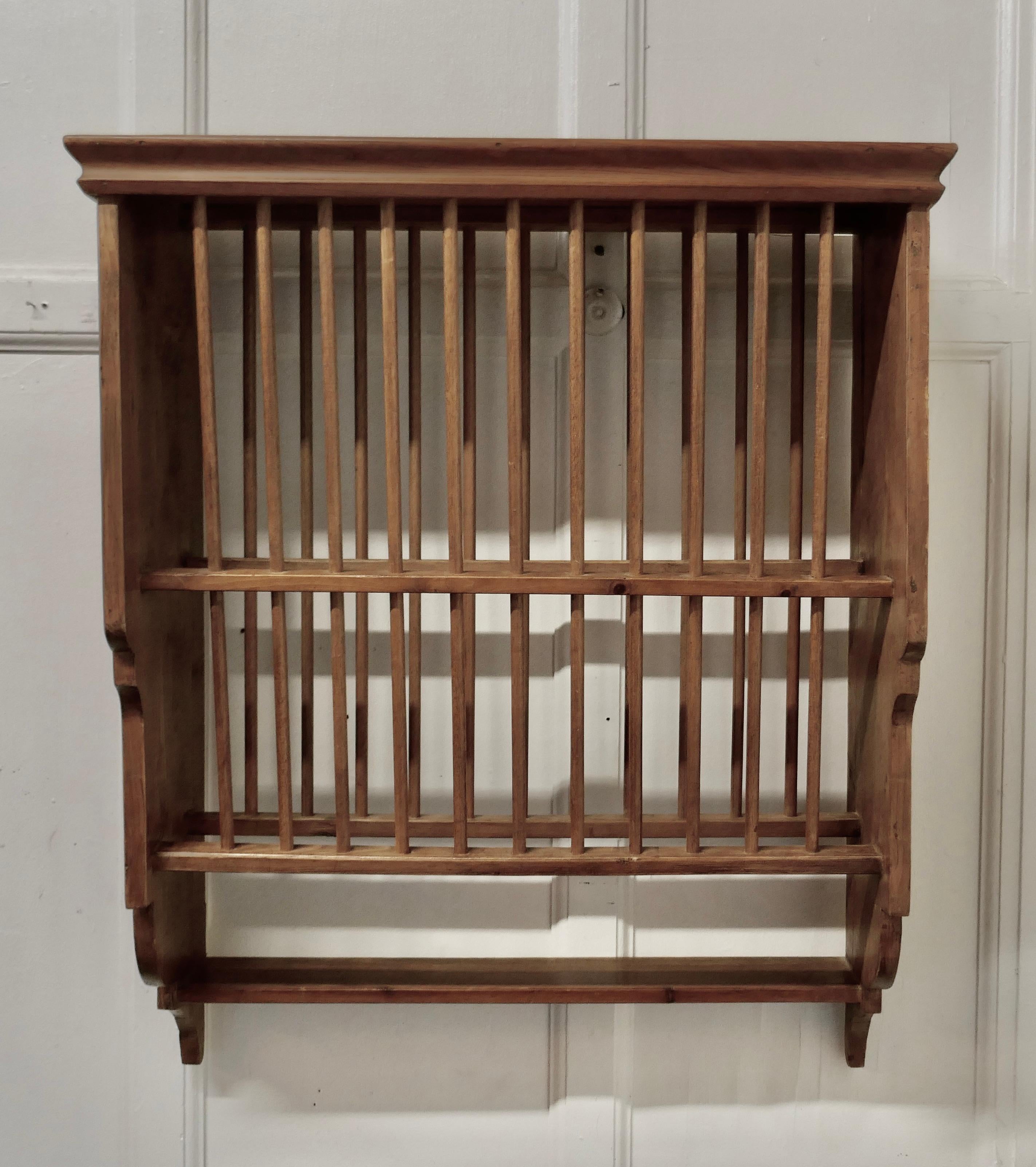 A Large wall hanging pine plate rack


This useful piece hangs on the wall and drains and stores plates until required
It has a pine frame and wooden dowels with a waterfall shape, allowing 2 rows of plates to be stored at any one time, below