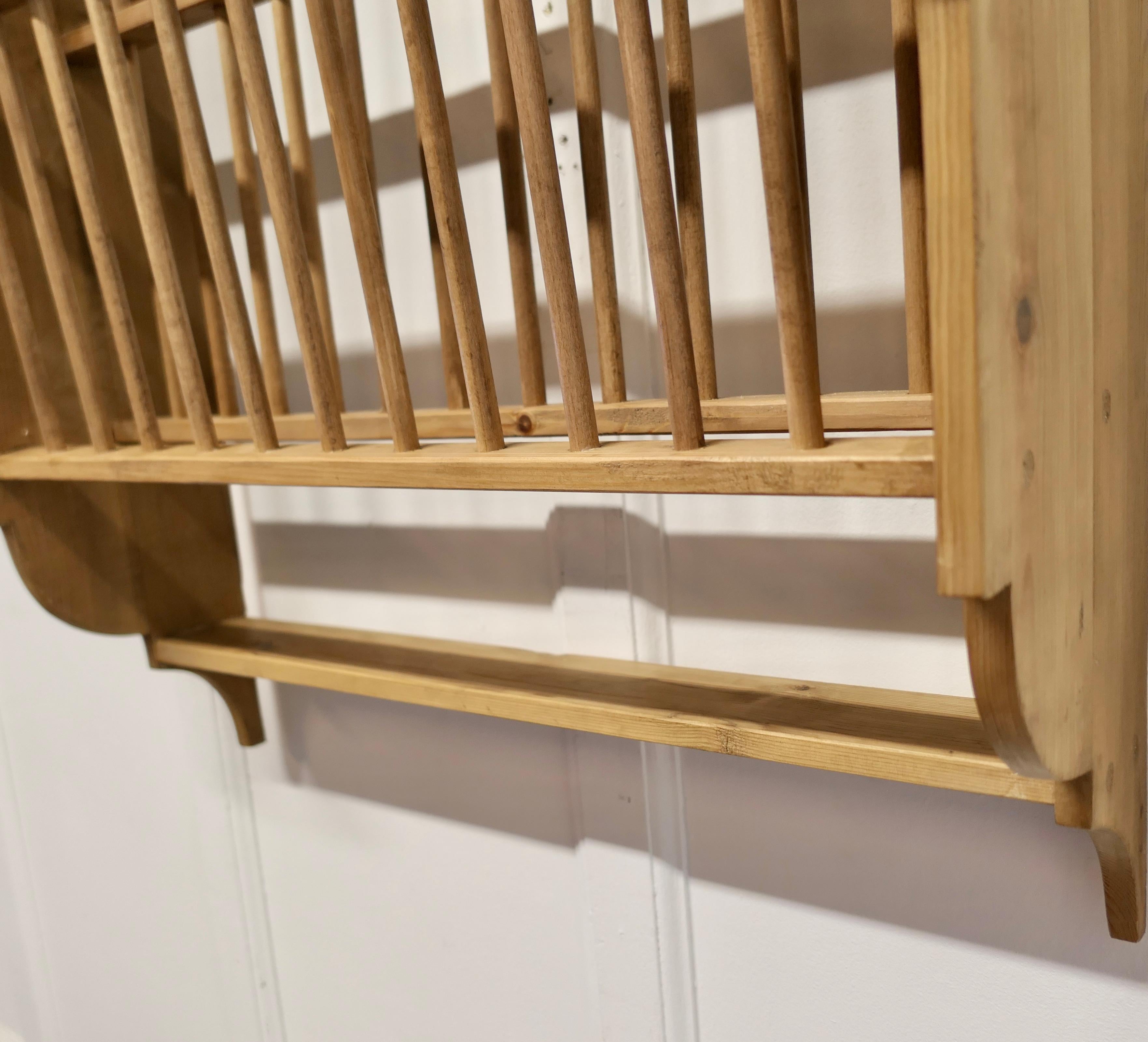 A Large Wall Hanging Pine Plate Rack

This useful piece hangs on the wall and drains and stores plates until required
It has a pine frame and wooden dowels with a waterfall shape, allowing 2 rows of plates to be stored at any one time, below there