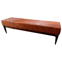 A large walnut bench with woven leather