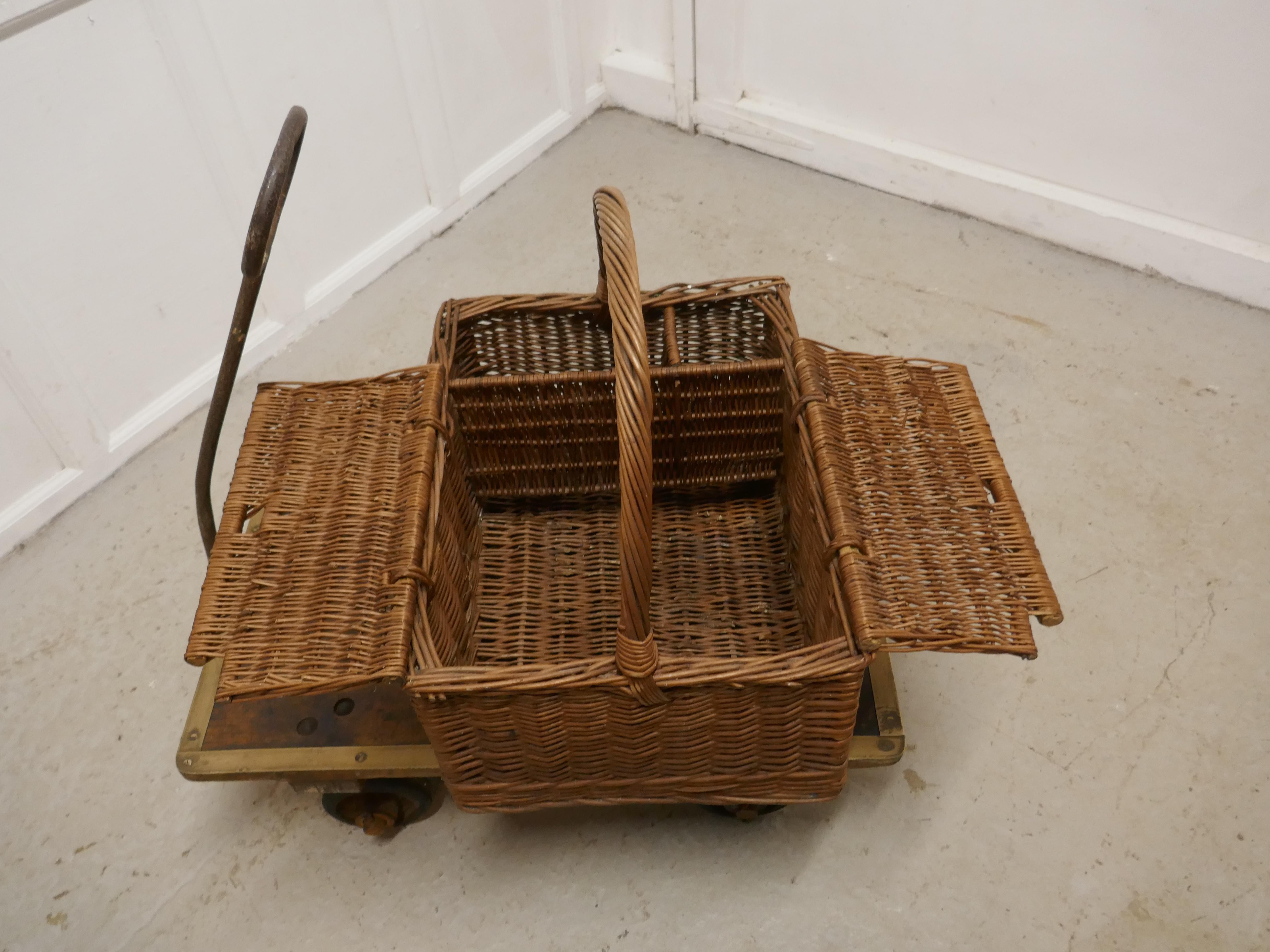 A large wicker picnic basket

An attractive age darkened wicker rectangular basket with big handle, the basket is woven and has 3 sections, the large section has a pair of lids and the open sections are for taller pieces like bottles and flasks to
