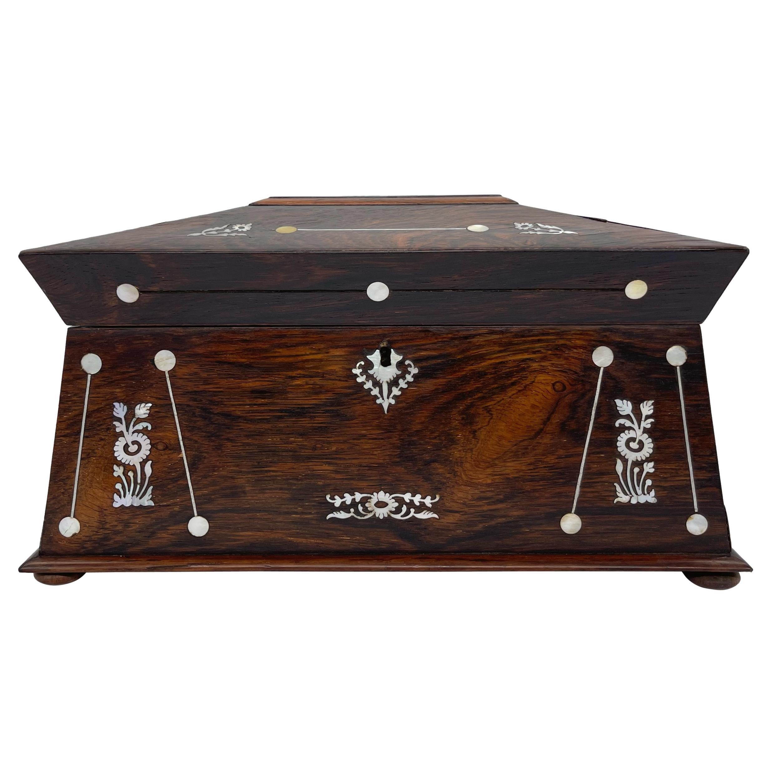 An unusually large William IV rosewood tea caddy, of sarcophagus form with finely inlaid mother-of-pearl medallions with stylized flowers acanthus leaves, the escutcheon plate with further similar decoration, the interior with both original rosewood