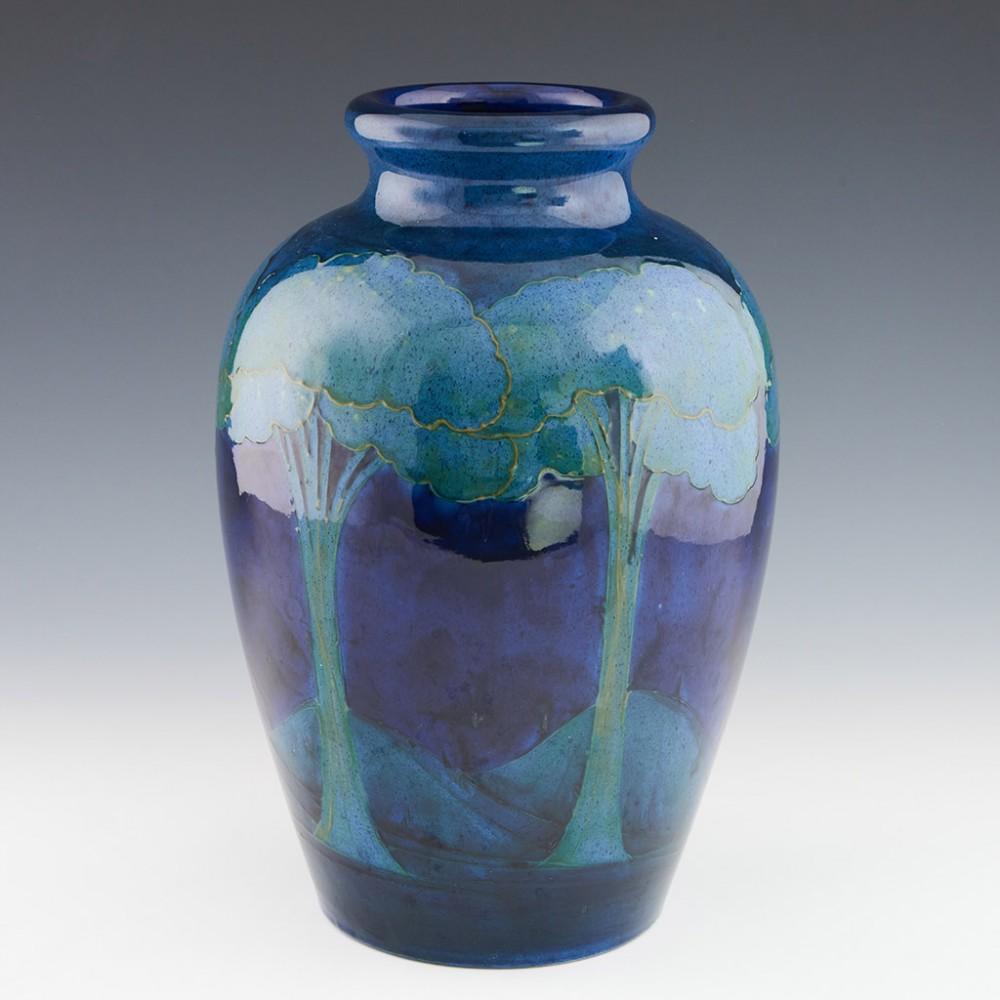 Heading : Large Moorcroft pottery vase 
Date : c1925
Origin : Burslem, Stoke-on-Trent
Bowl Features : Deep blue with pale blue and green trees. 
Marks : Moorcroft Made in England to the base
Size : 32cm height, 21cm diameter. 
Condition :