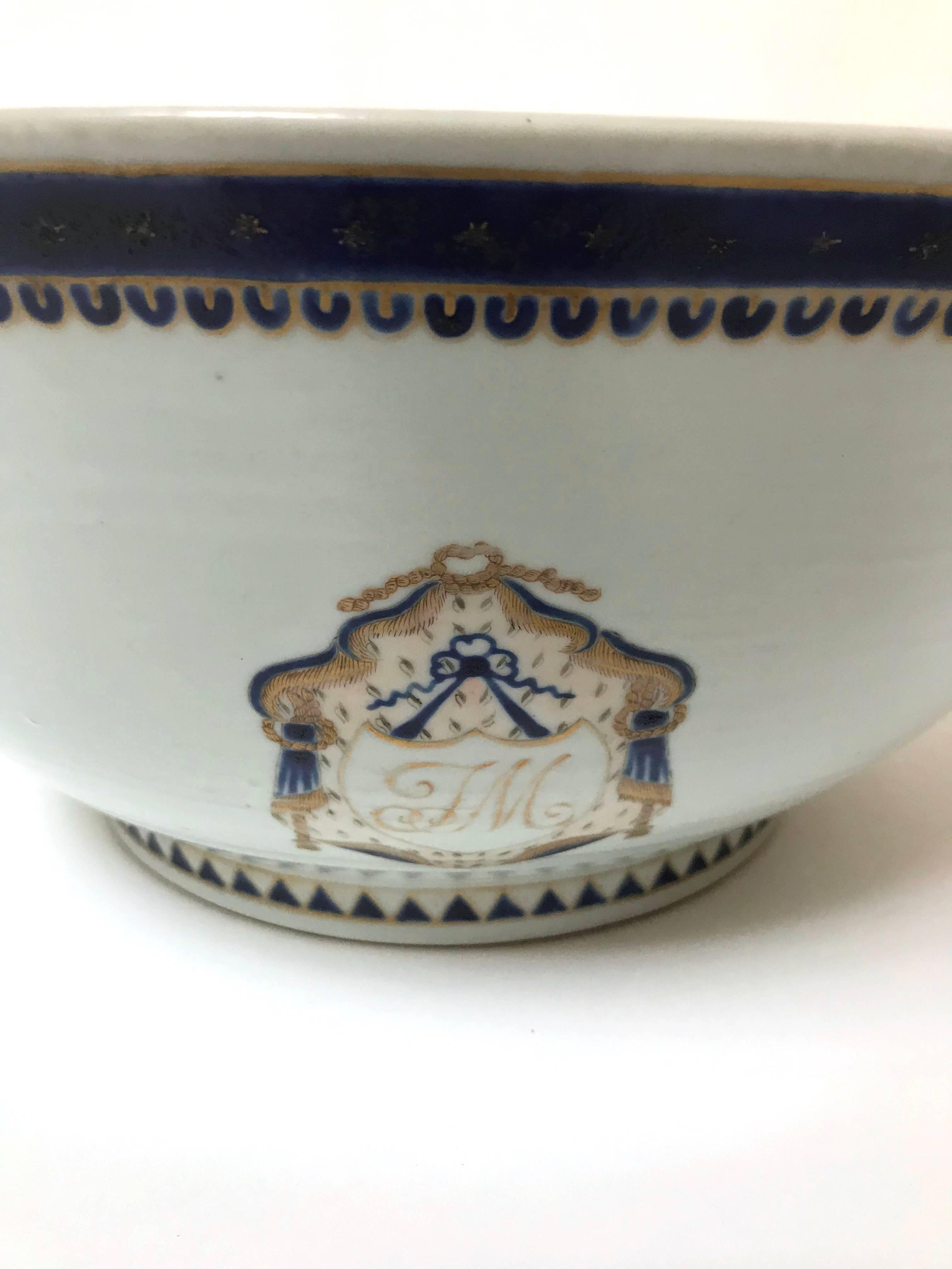 A large Chinese export armorial porcelain punch bowl, circa 1790-1810, heavily potted and decorated with two armorial devices, each on opposing sides, consisting of a cursive monogram 