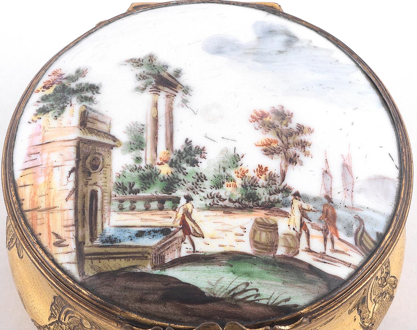 Le couvercle est orné d'un panneau émaillé représentant un Capriccio portuaire, le dessous est peint d'un moustique, les côtés bombés sont gravés de diverses volutes de rocaille avec une base en écaille pressée, diamètre 6.3cm.