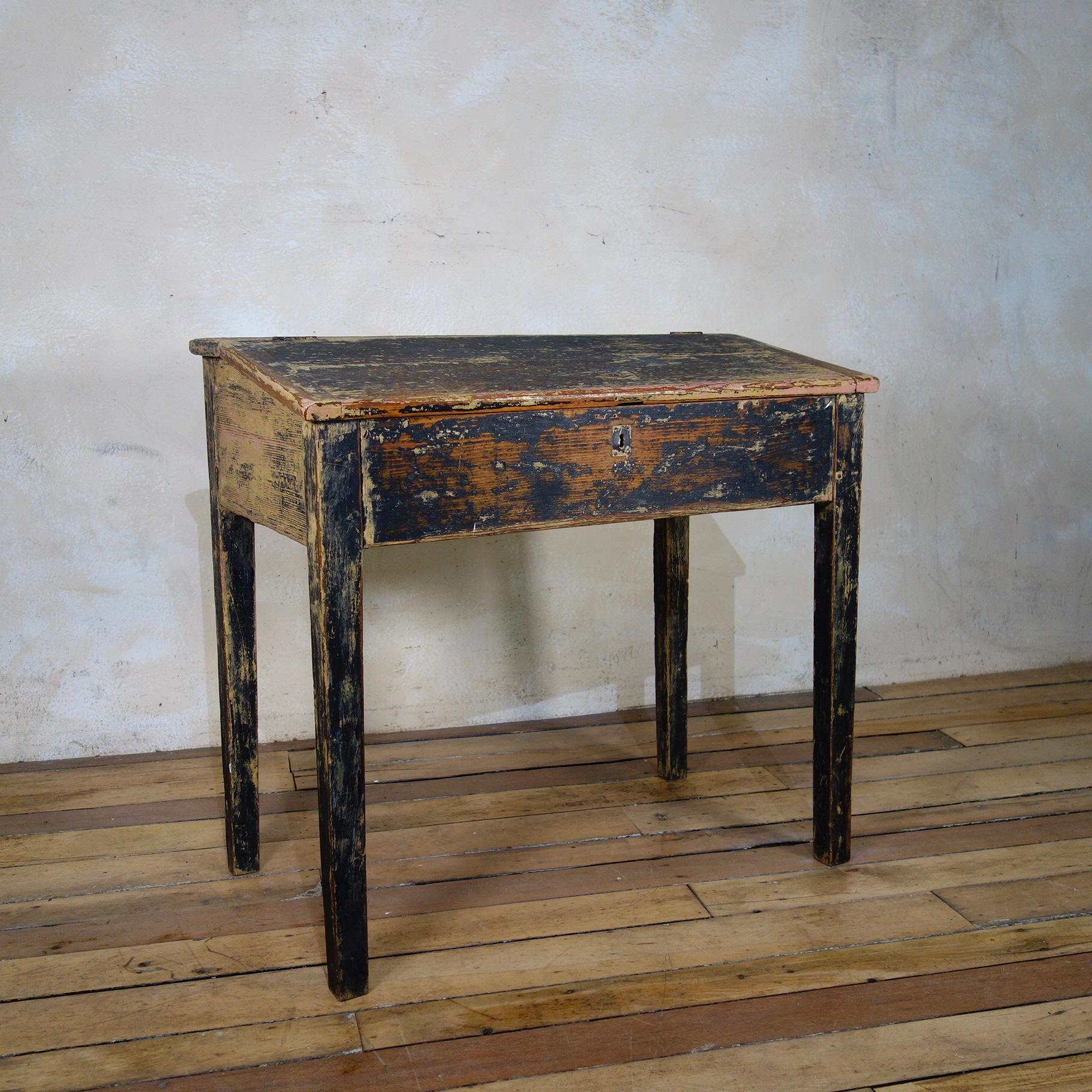 A late 18th century French primitive slanted school desk. Featuring its original dry scraped paint, raised on tapering legs. 
 
Measures: Height - 78cm
Width - 84cm 
Depth - 45cm.