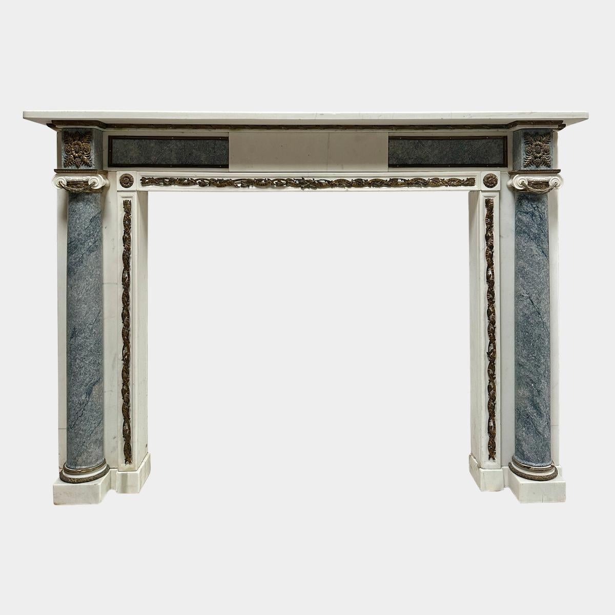 Englischer Kamin aus statuarischem Marmor aus dem späten 18. Jahrhundert mit Säulen und Platten aus grauem Sparmarmarmor. Eine schlichte Tafel in der Mitte wird auf beiden Seiten von blau/grauen Marmorplatten flankiert, die von vergoldetem Messing