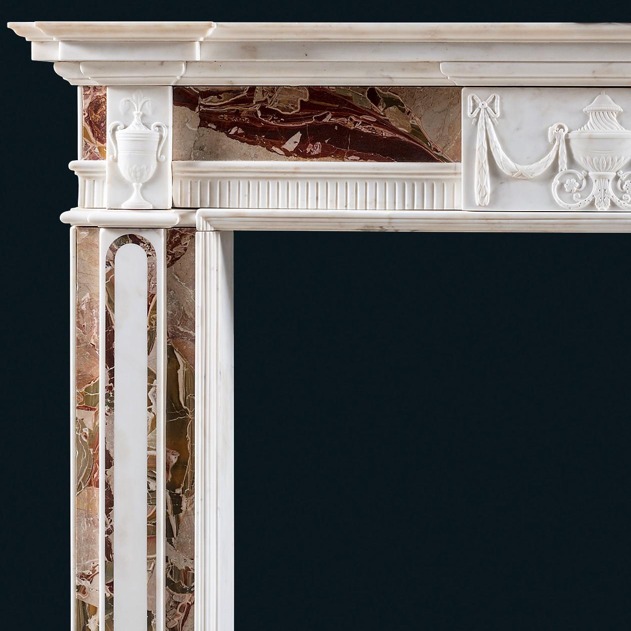 A late 18th century Irish neoclassical statuary marble chimneypiece veneered with book-matched Jasper of exceptional quality, the central tablet carved with a Tazza urn spraying with acanthus leaves from the base, with festoons hanging from ram head