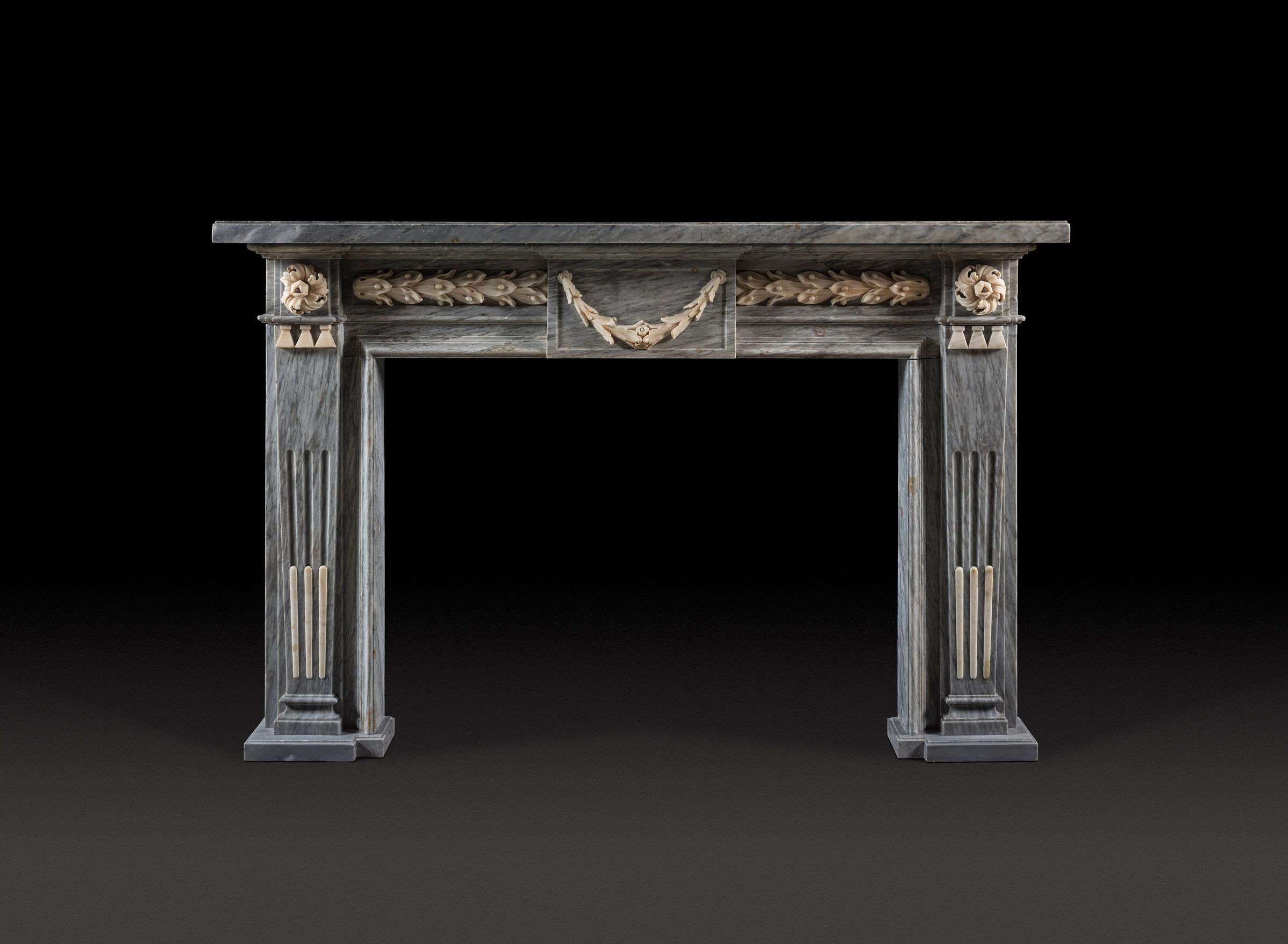 Cheminée nord-italienne de la fin du XVIIIe siècle, sculptée en marbre bleu turquin avec des détails statuaires

La tablette simple repose sur la frise centrée par une tablette représentant une guirlande de laurier. Le feuillage se poursuit dans la