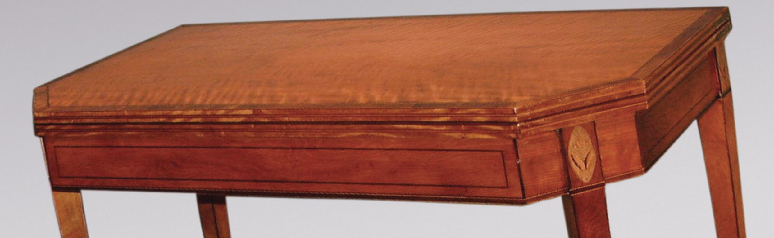 Une fine table à cartes en bois de satin de la période Sheraton de la fin du 18e siècle, avec des bandes croisées en bois de rose et des cordes en buis et en ébène, avec un plateau à angle droit au-dessus d'une frise de panneaux avec des patères