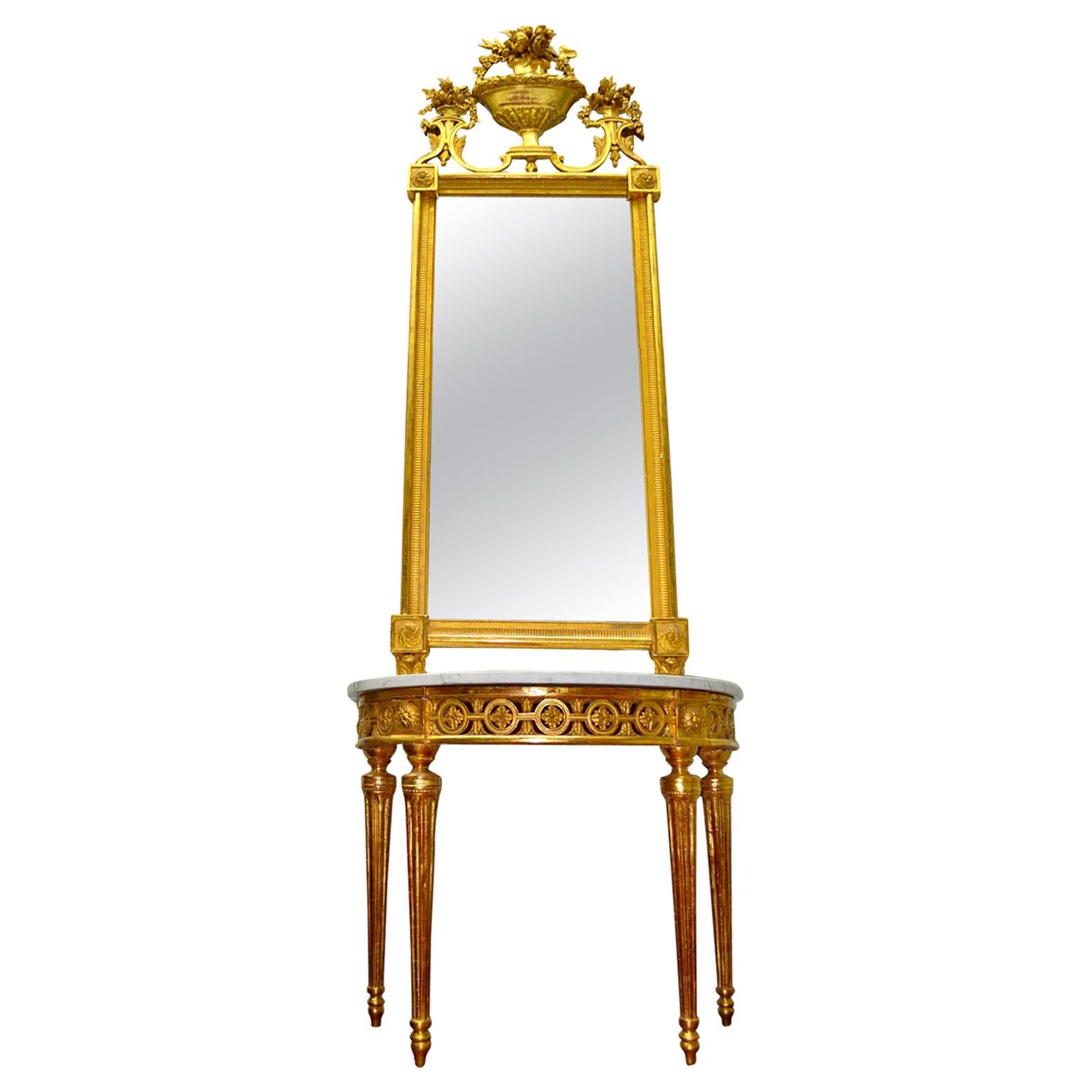 An important 18th century Italian giltwood mirror over a conforming demilune giltwood console table having a white marble top. The table has a carved open work apron with decorative circles framing rosettes joined with leaf work, large carved