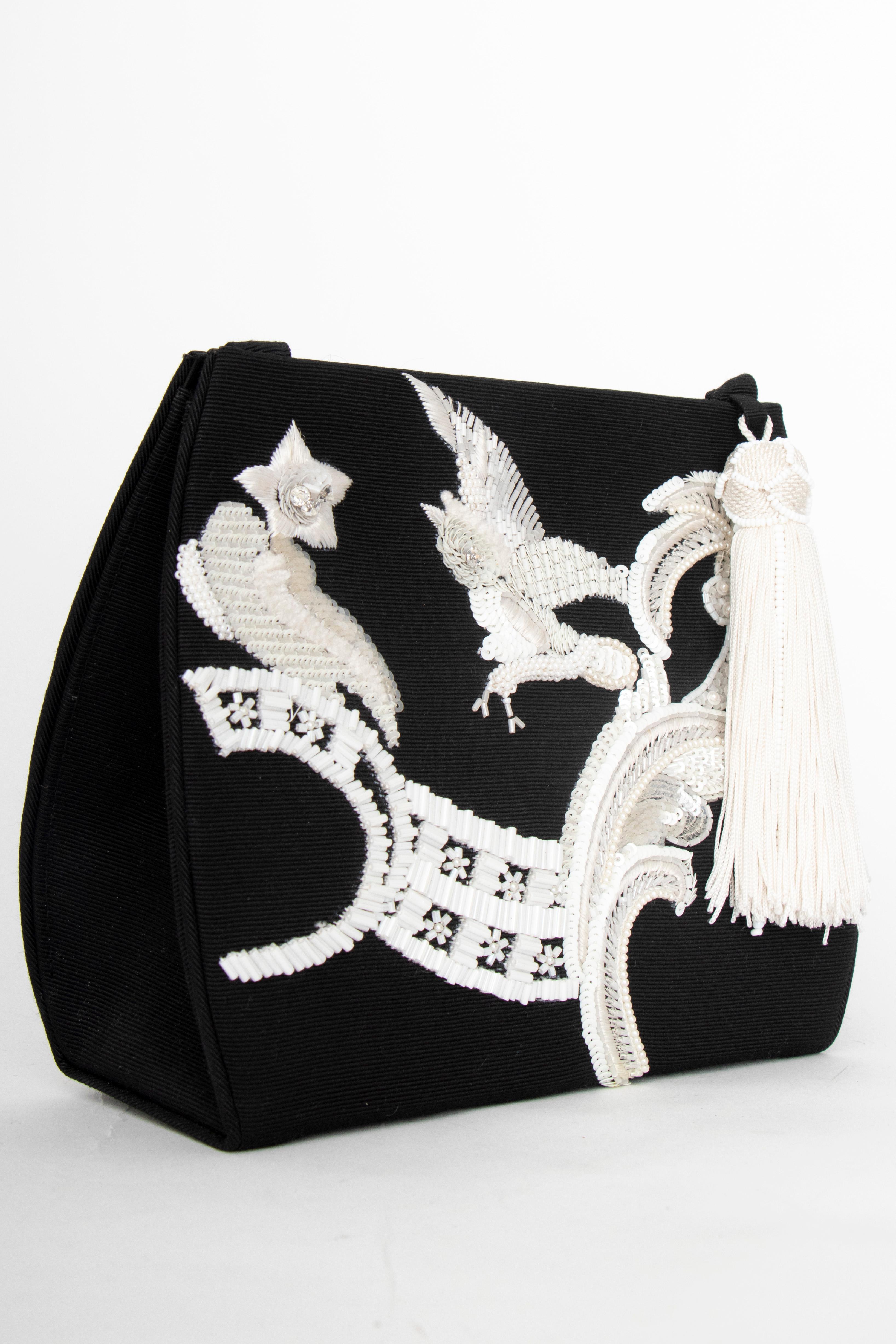 An incredible 1990s Christian Dior by John Galliano black evening bag with a thin shoulder strap and push-button closure. A bead and sequin owl and paisley motif adorn the front and a white tassel detail is placed at the top. 

The bag has the