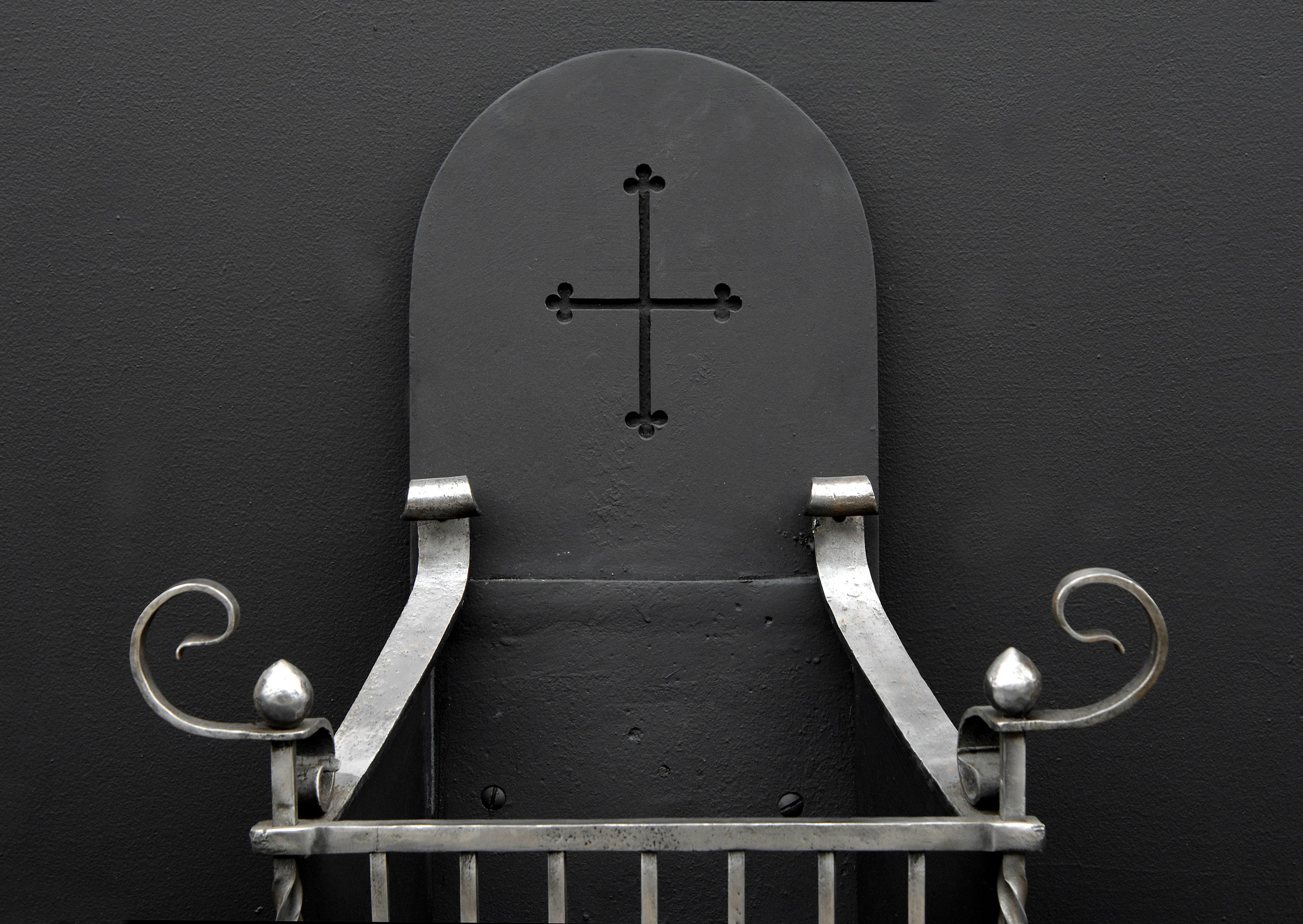 A late 19th century arts and crafts polished wrought iron firegrate. Scrolled feet and upright barley twist bars surmounted by scrolls. Shaped back with pierced cross to centre.


Width At Front:	635 mm      	25