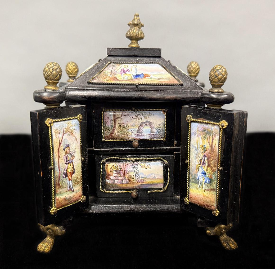 Boîte à bijoux en bronze et émail viennois de la fin du XIXe siècle

La belle boîte à bijoux très décorée avec des plaques émaillées détaillées, les deux portes s'ouvrant sur deux tiroirs avec des scènes de paysage, les panneaux environnants et