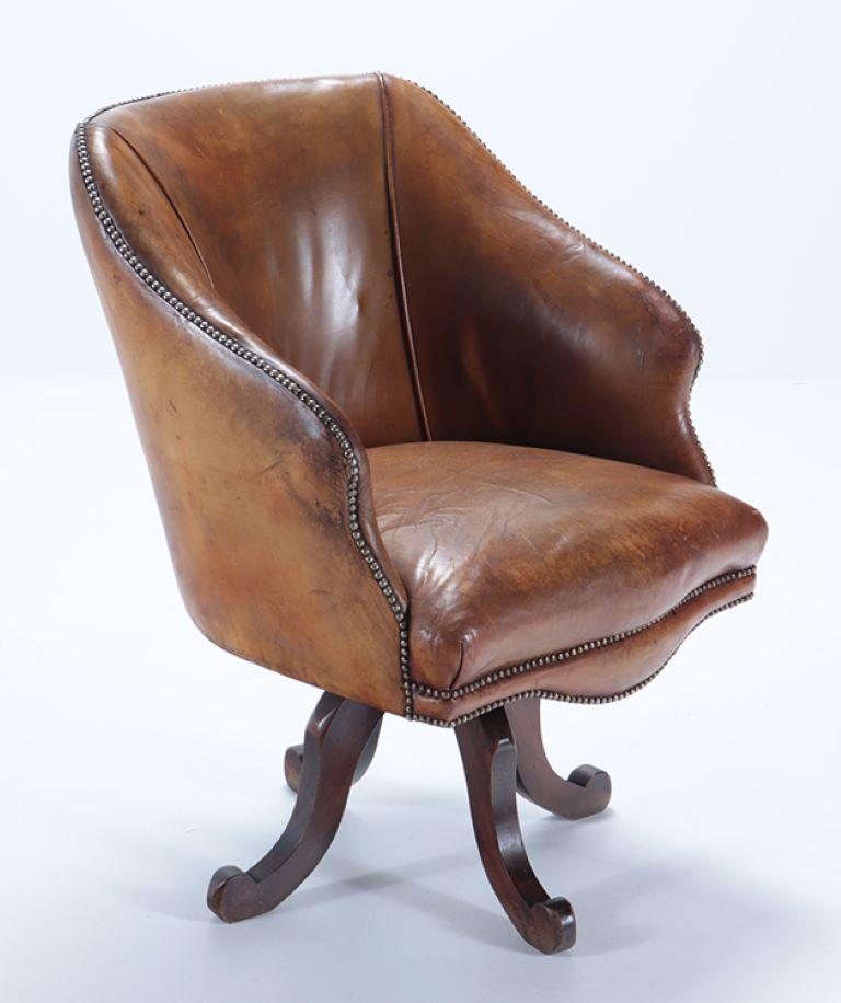 French A late 19th Century Continental leather swivel desk chair with nail head trim.