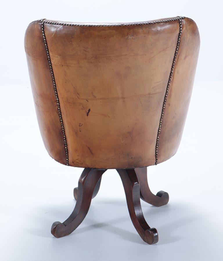 A late 19th Century Continental leather swivel desk chair with nail head trim. 2