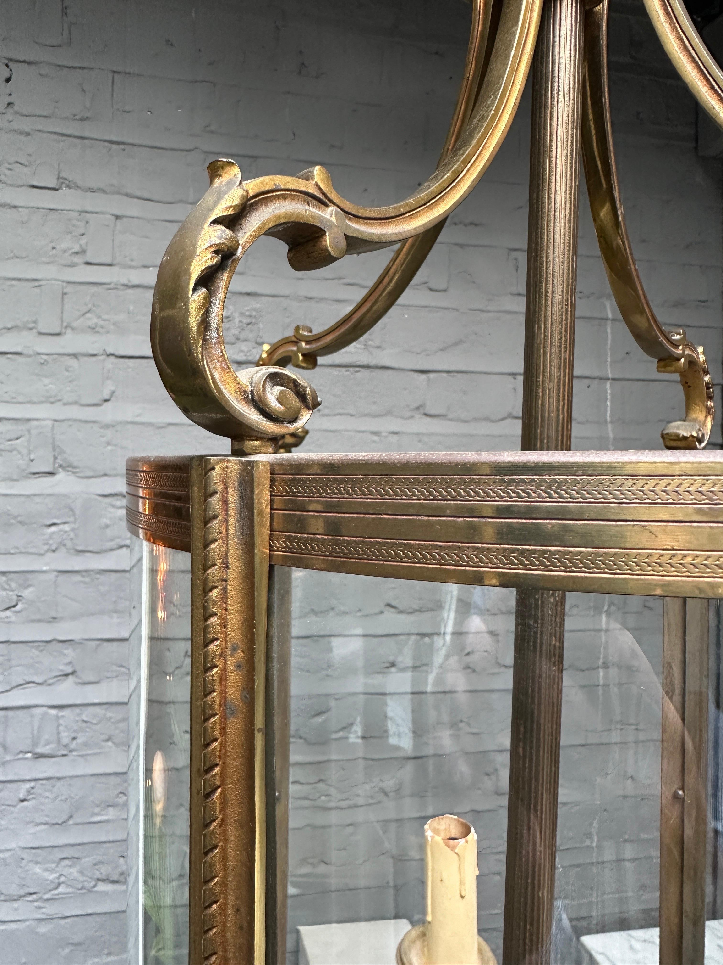 A Gilt bronze late 19th century French lantern. The 4 curved glass panels surrounding a 4 arm branch with reeded stem and scrolled acanthus arms, The centre finished with an acorn finial. The frame of chased bronze work with finials on bottom and