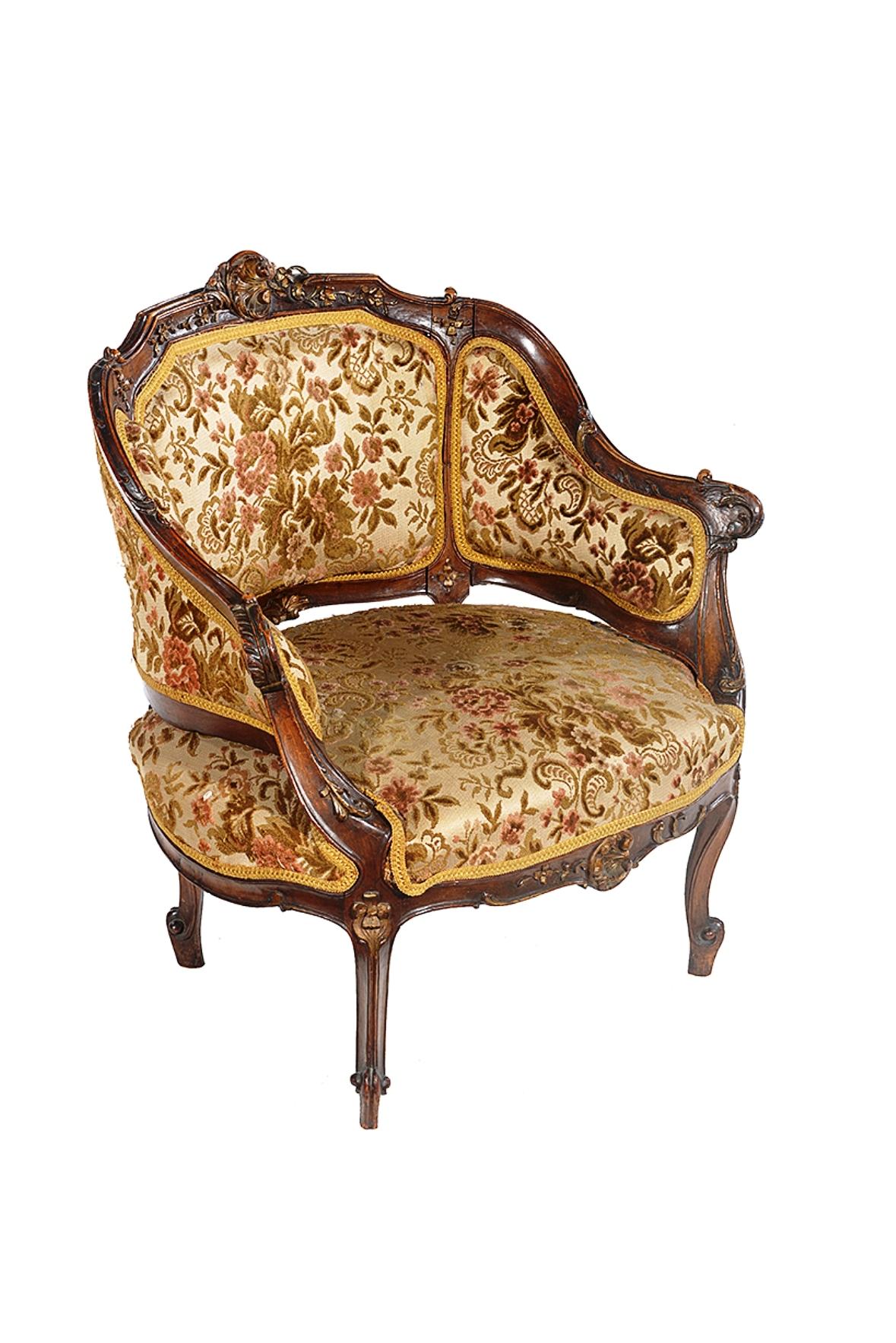 A late 19th century French Louis XV walnut framed bergère chair of petite proportions.
The moulded frame carved with leaves and flowers, the padded back, sides and seat upholstered in a plush floral fabric, the whole raised on scrolling cabriole
