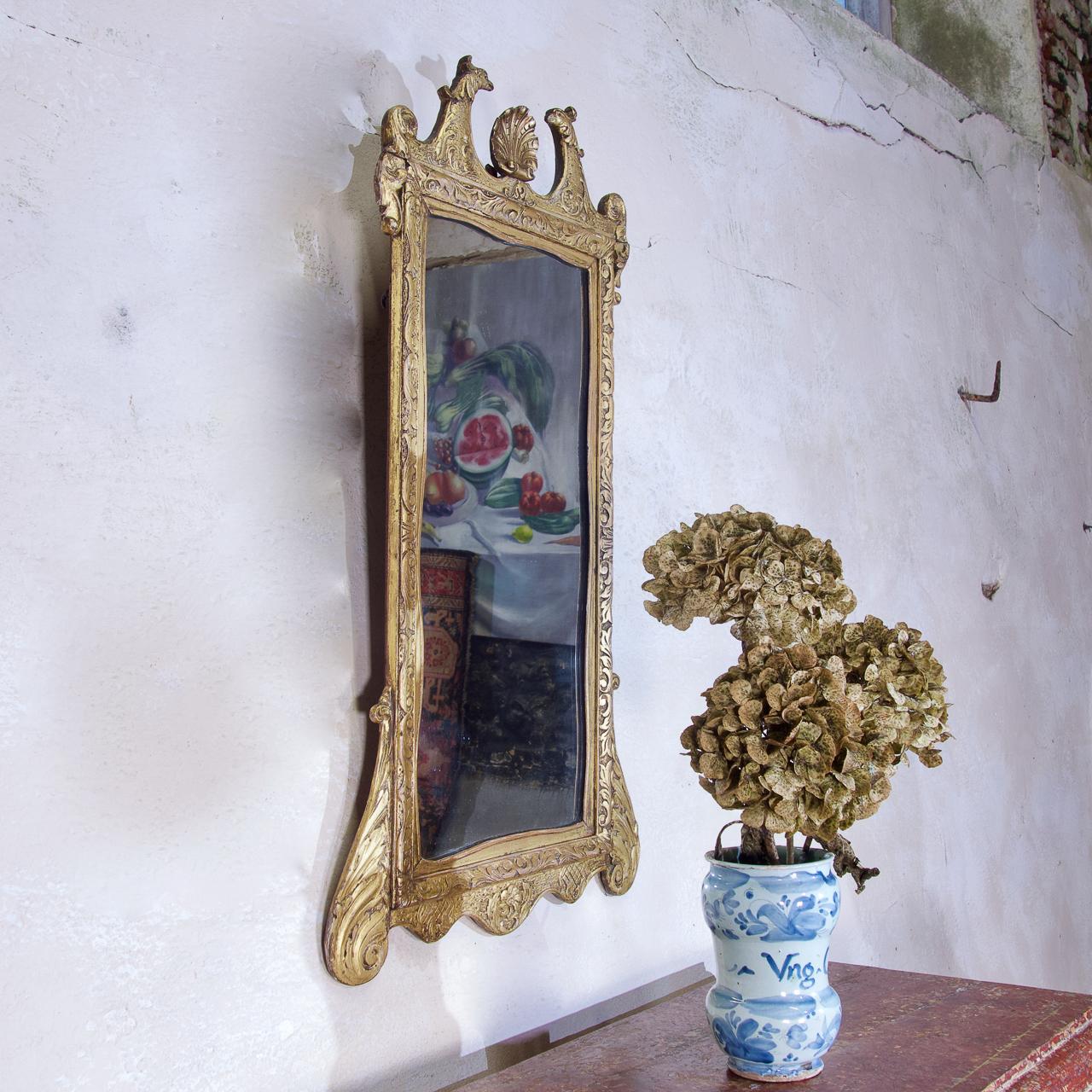Miroir mural très décoratif en bois doré de style George II de la fin du XIXe siècle. La dorure présente un beau ton, ajoutant une grande profondeur au cadre du miroir.
Le cimier est orné d'un aigle double, de feuillages stylisés et d'enroulements