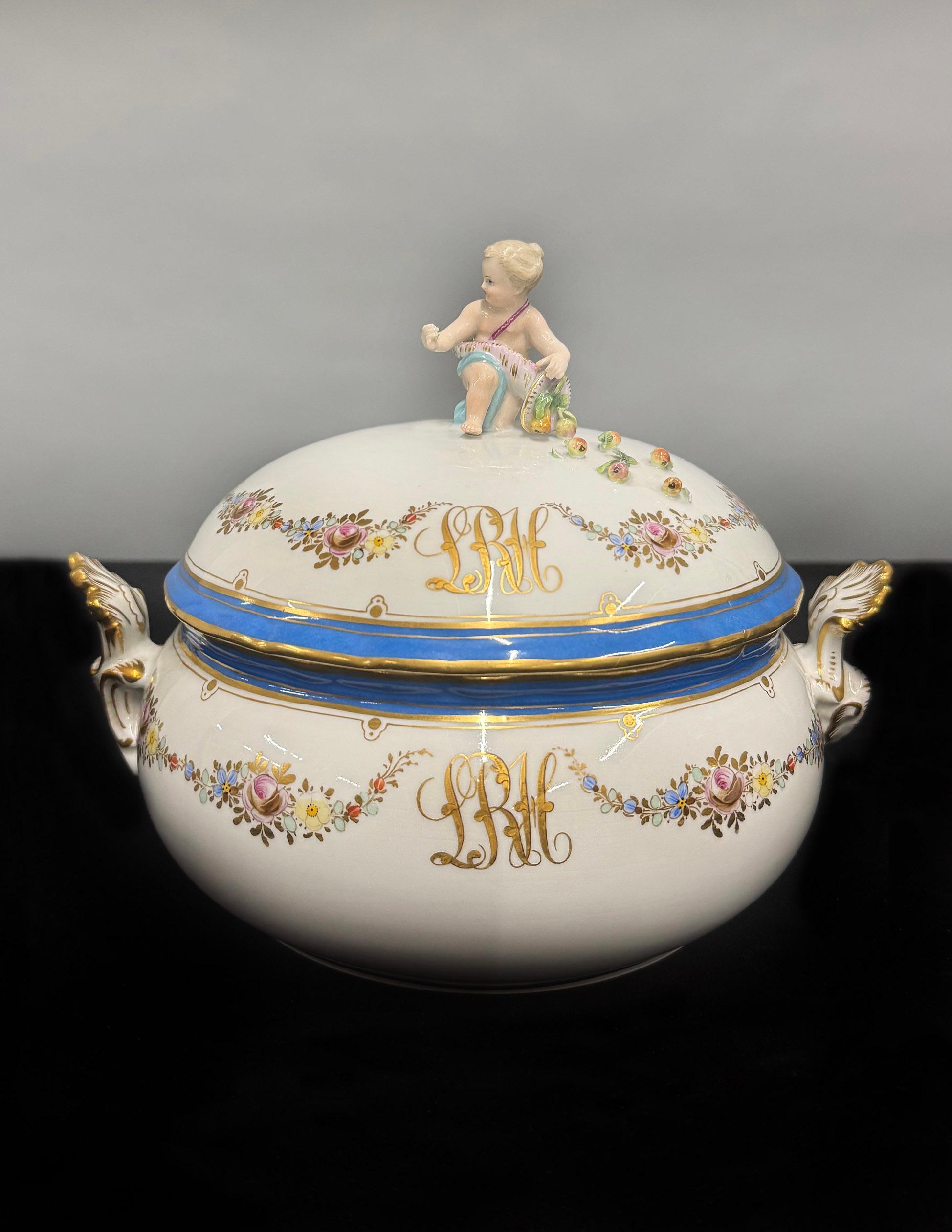 Soupière / Centre de table en porcelaine Meissen allemande de la fin du 19e siècle

Le bol à couvercle en porcelaine finement peinte est surmonté d'un chérubin agenouillé et drapé dans un vêtement fluide, tenant une corne d'abondance basculant sur