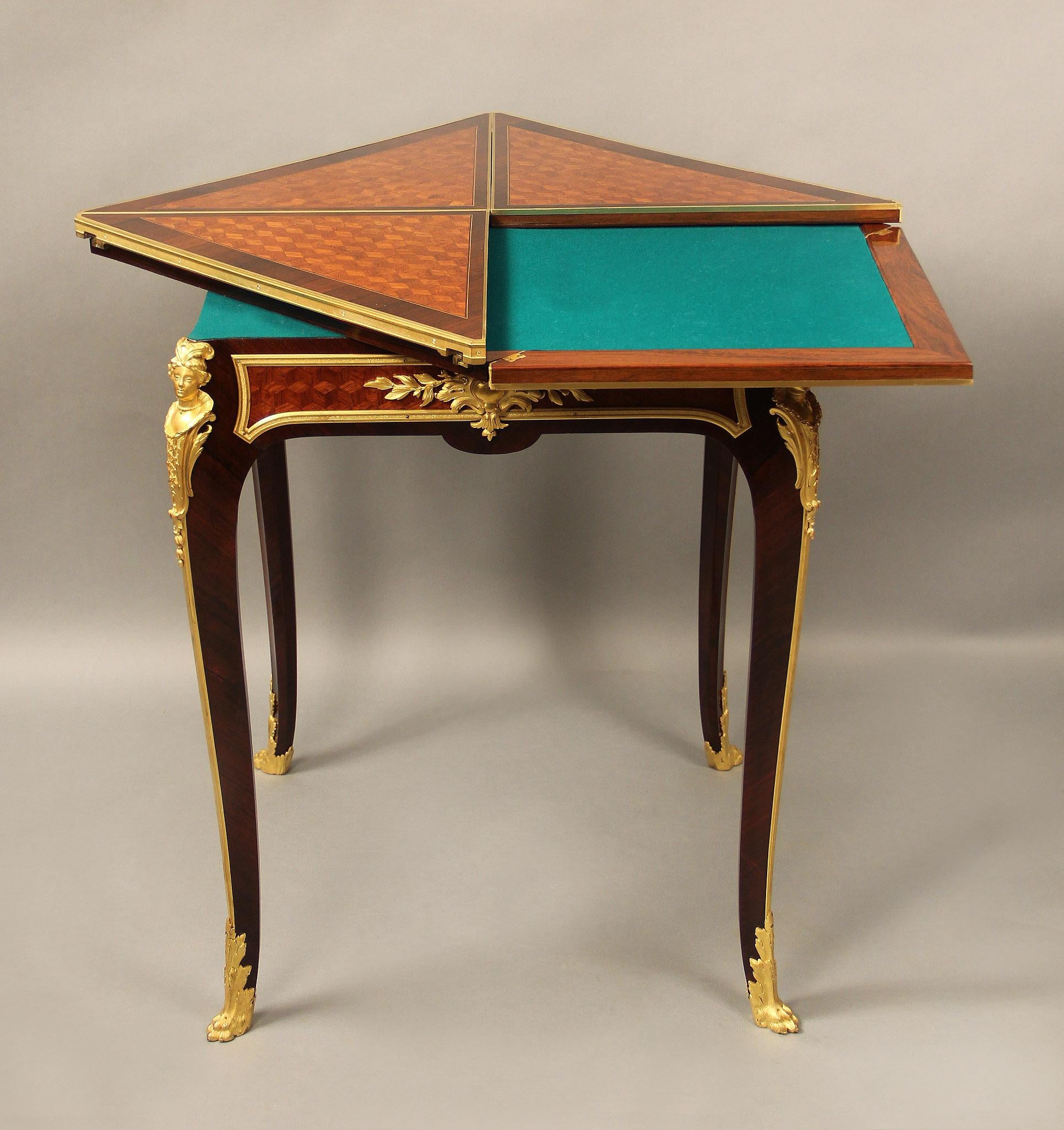 A wonderful late 19th century gilt bronze mounted parquetry envelope game table by François Linke

François Linke – Index no. 523

The revolving top with four triangular leafs, opening to green baize-lined playing surface above a frieze fitted