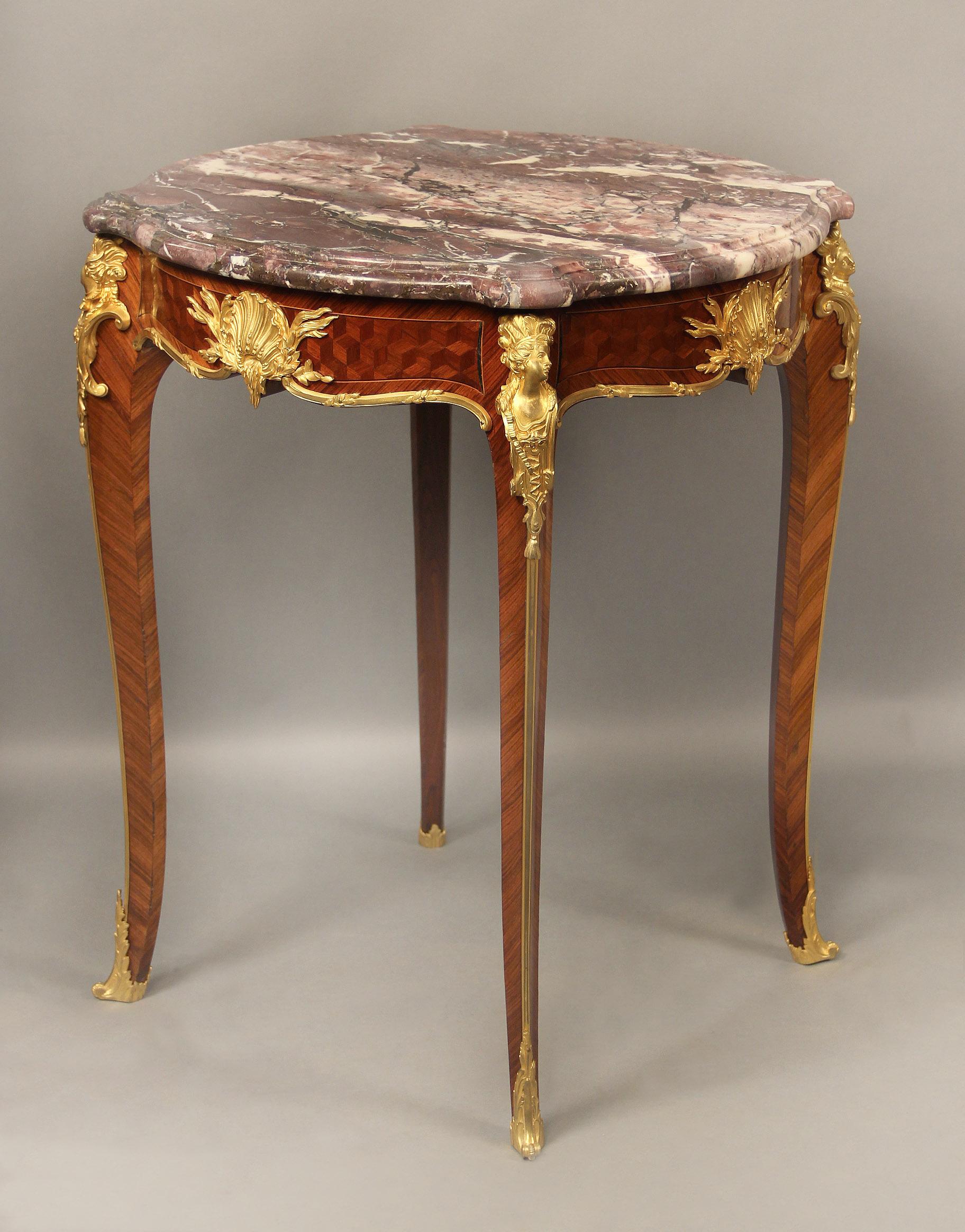 A fine late 19th century Louis XV style gilt bronze mounted cube parquetry guéridon

By François Linke

A marble top above the table decorated to all sides with a gilt bronze leaf-clasped scallop shell mount and to each corner with an