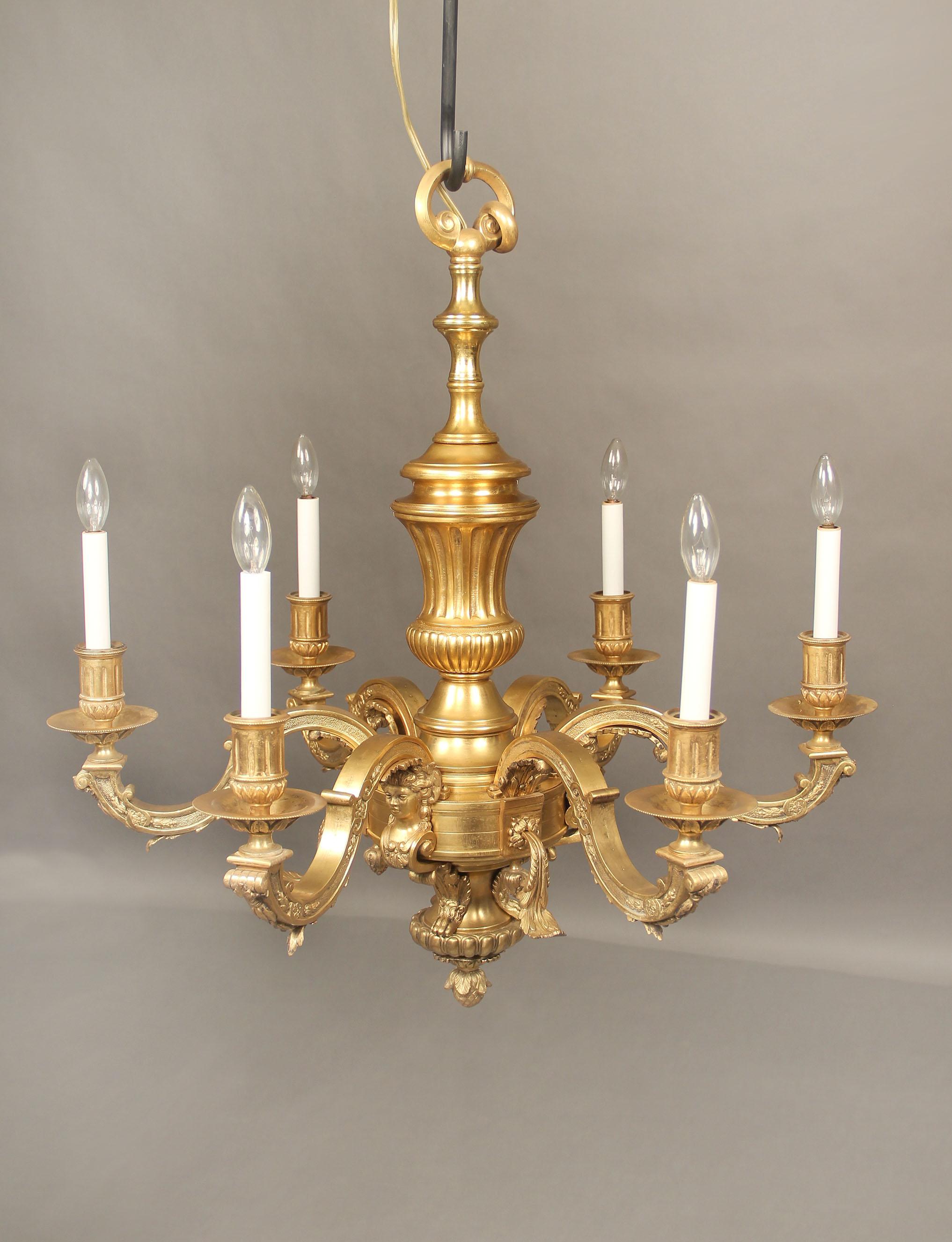 A late 19th century gilt bronze six light chandelier

The bronze frame with women busts and lion paw feet along the base, the arms with leaves and foliage, six perimeter lights.