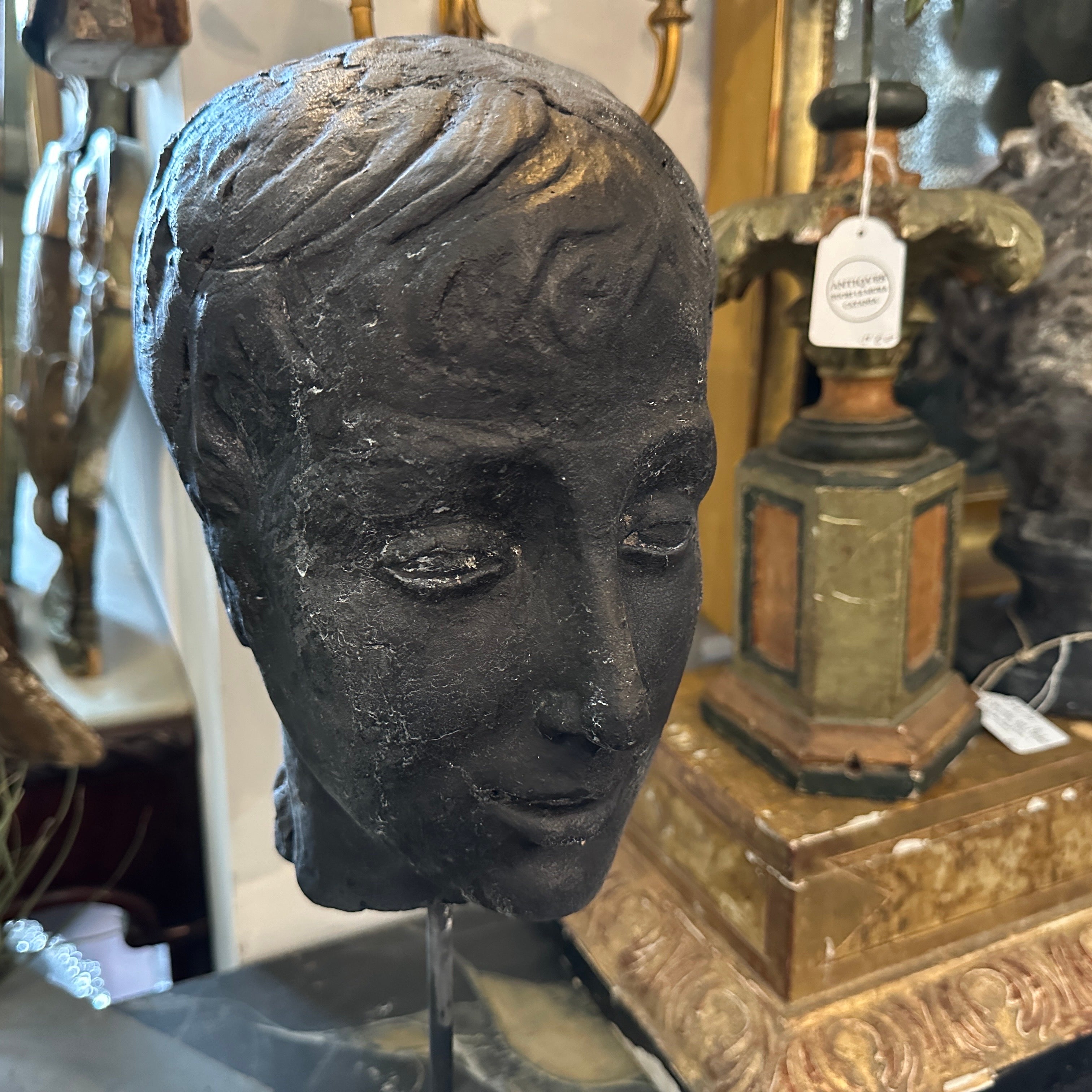 A black painted clay head handcrafted in Sicily in the late 19th century, the head it's in original condition and shows signs of aging, which contribute to their charm and authenticity, it has been mounted in an iron base that plays it down and