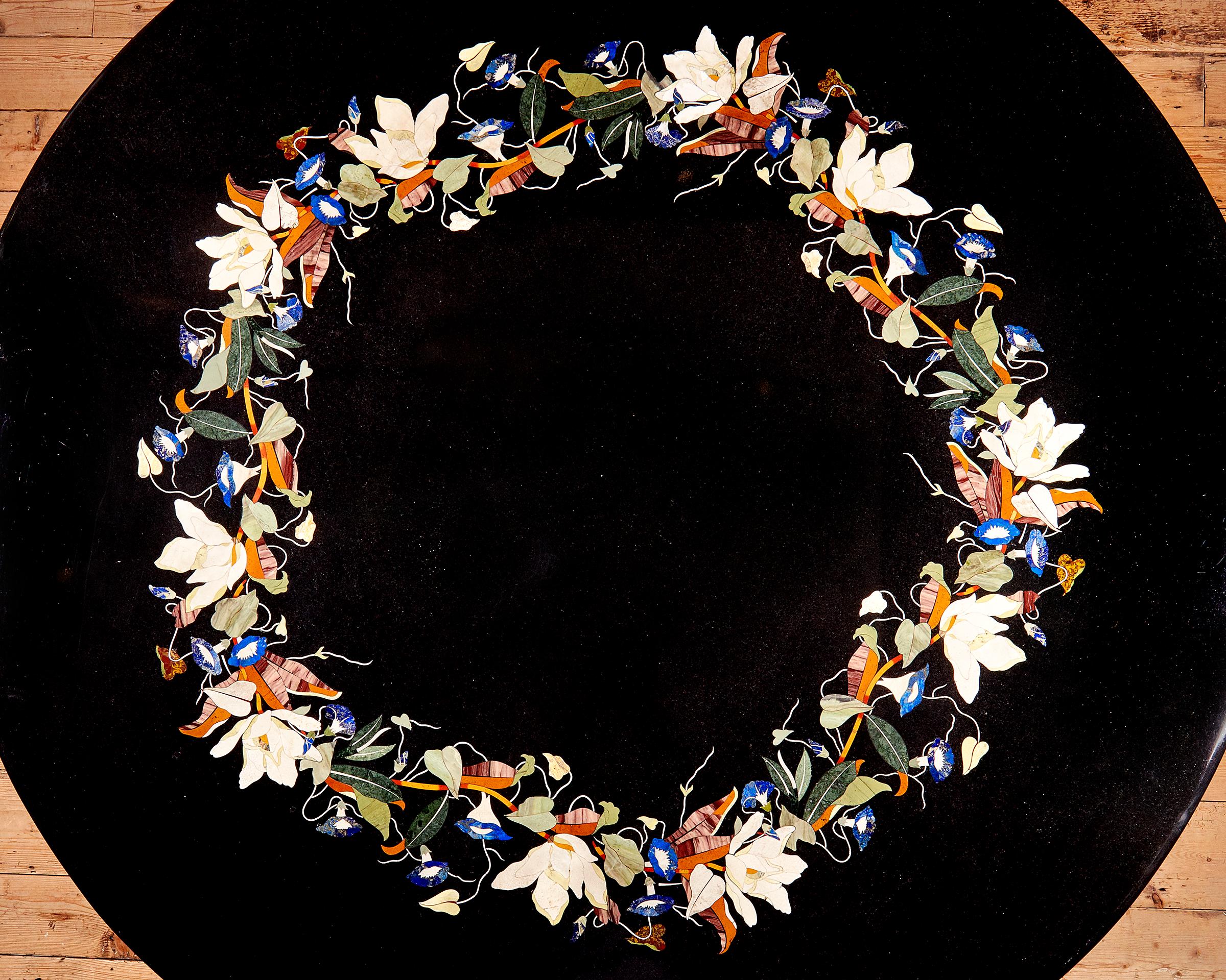 A large Italian Pietra Dura centre table, late 19th century, likely Florentine. The black marble top with an intricate inlaid polychrome trailing floral band, on a carved and painted wood central support in neoclassical style.