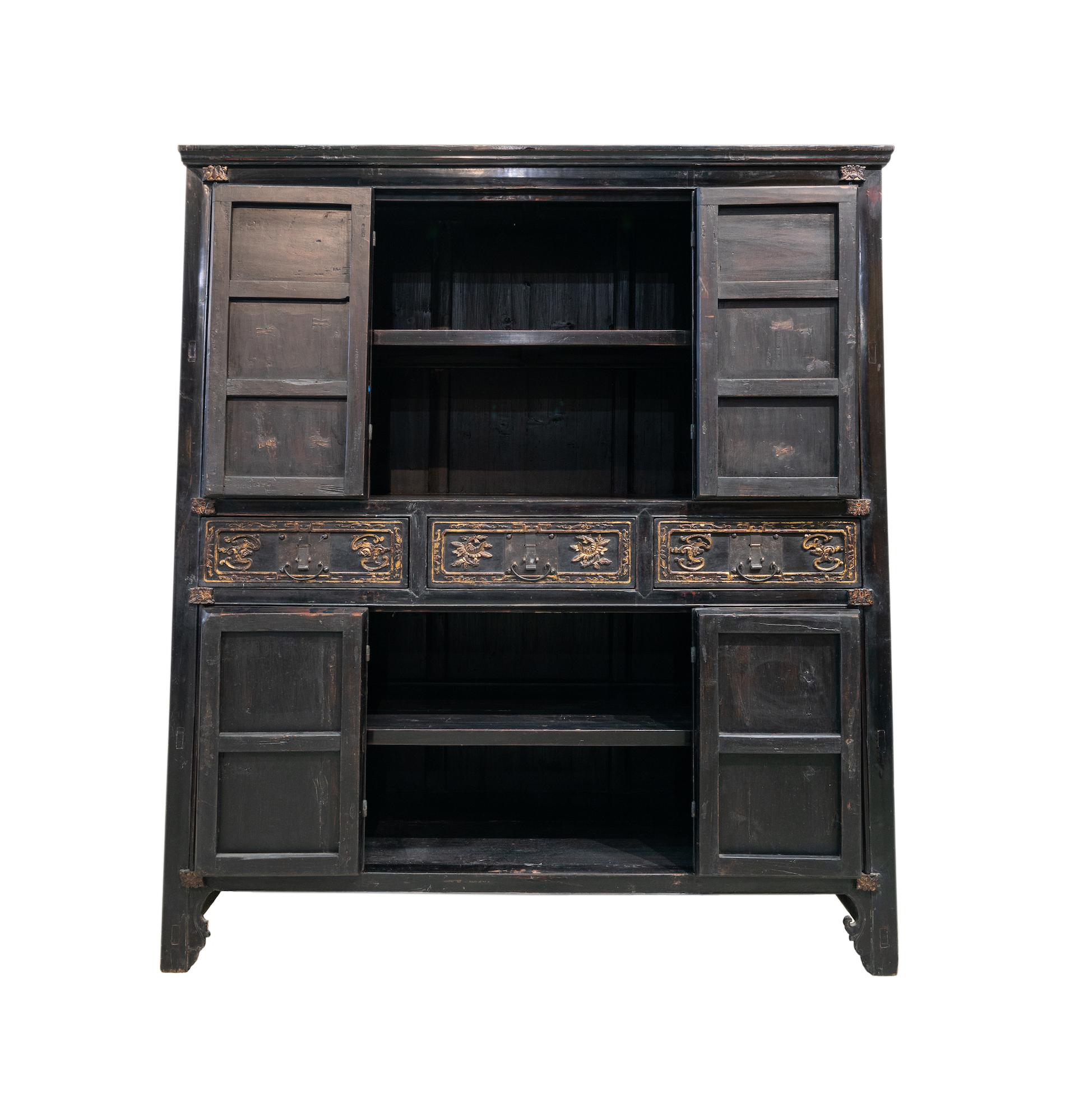 A late 19th century 8-door cabinet with carving from Dong Yang city, Zhejiang province, China. This design is very typical of cabinets from this region, which is famed for their wood carvings. The small carved panels on the top doors have intricate