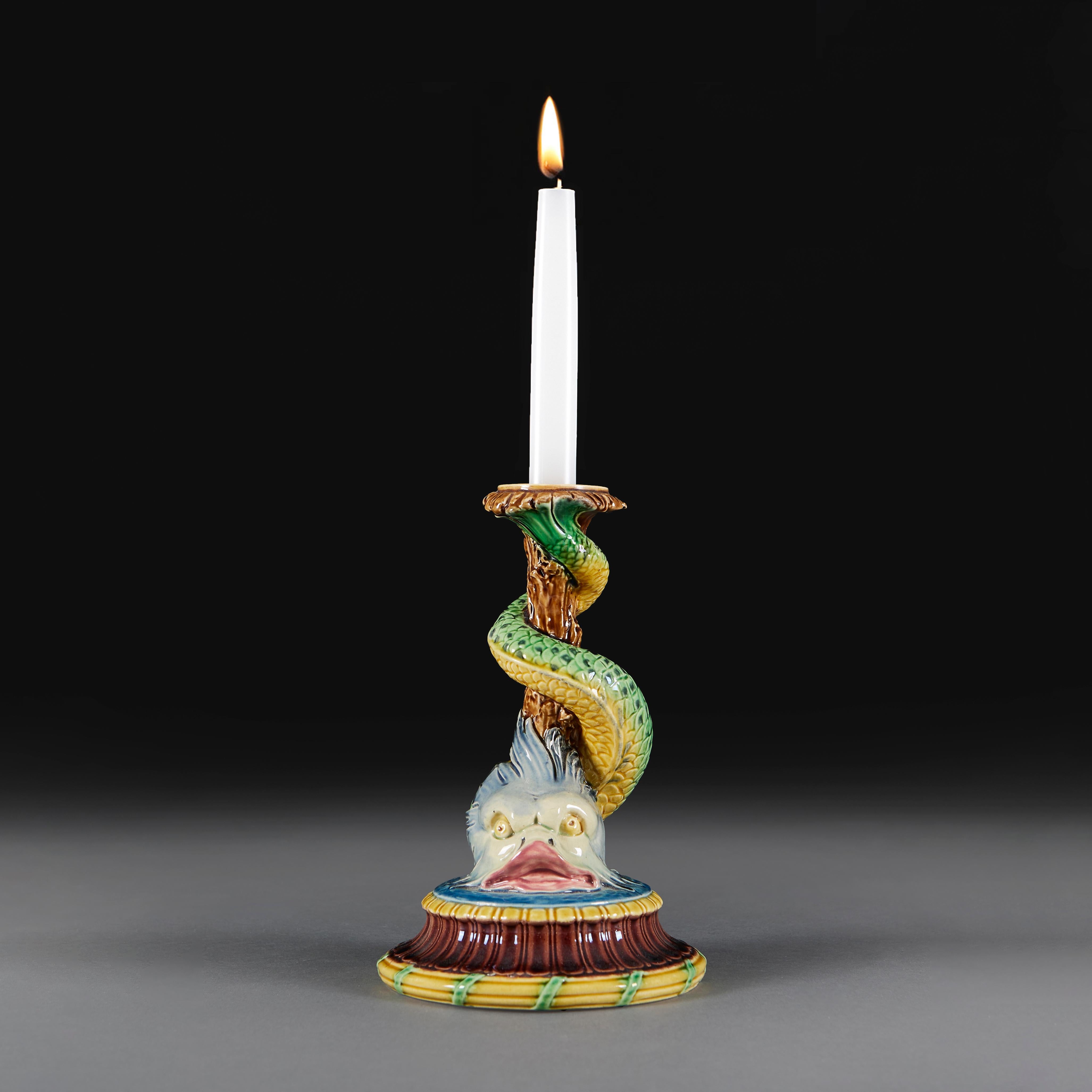 Candeliere in ceramica Minton della fine del XIX secolo, modellato a forma di delfino reclinato, sostenuto da una base circolare e dipinto con smalti policromi. Timbrato alla base.