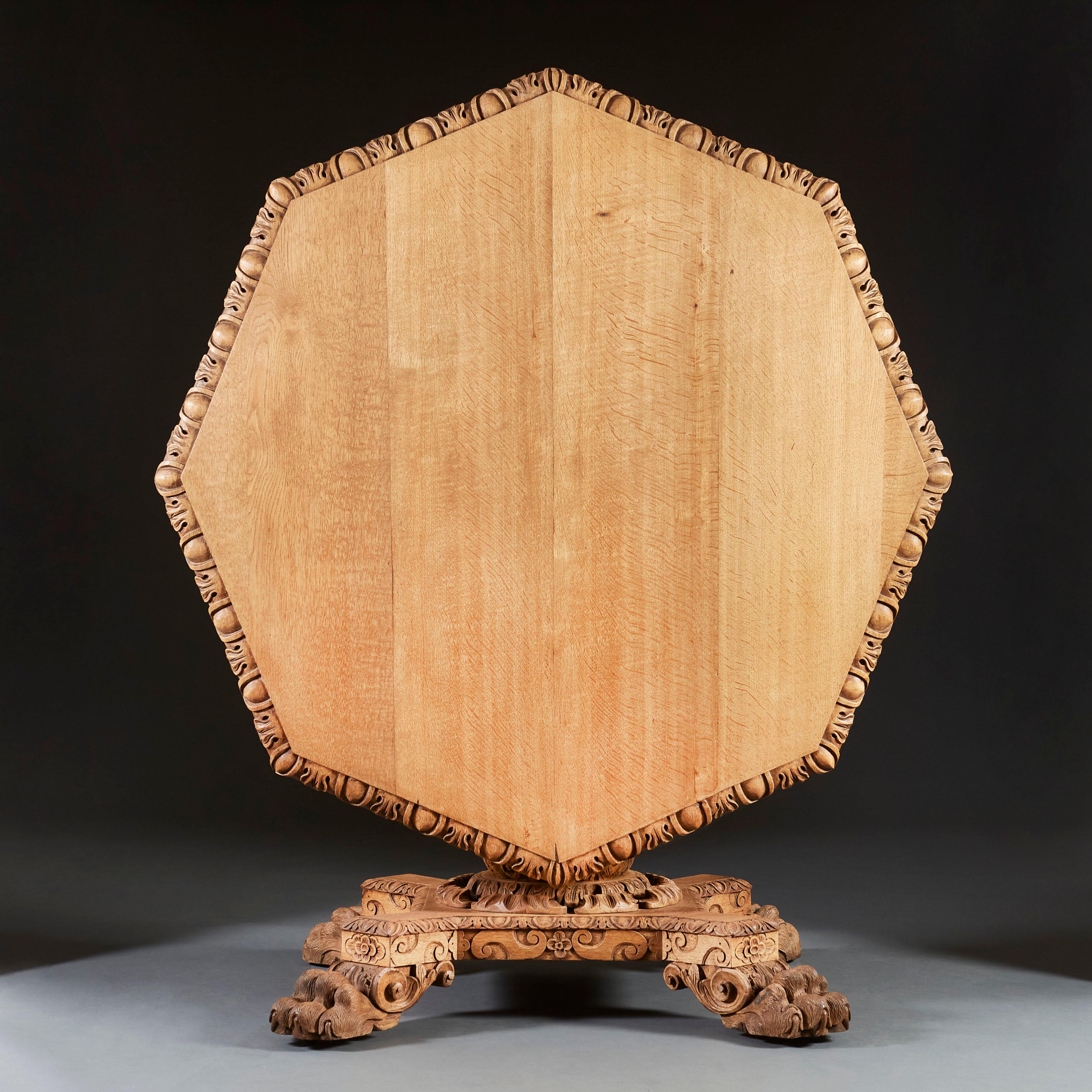 An unusual late 19th century oak centre table with an octagonal top, carved foliate frieze, and turned pedestal, all supported on three overscale hairy paws.