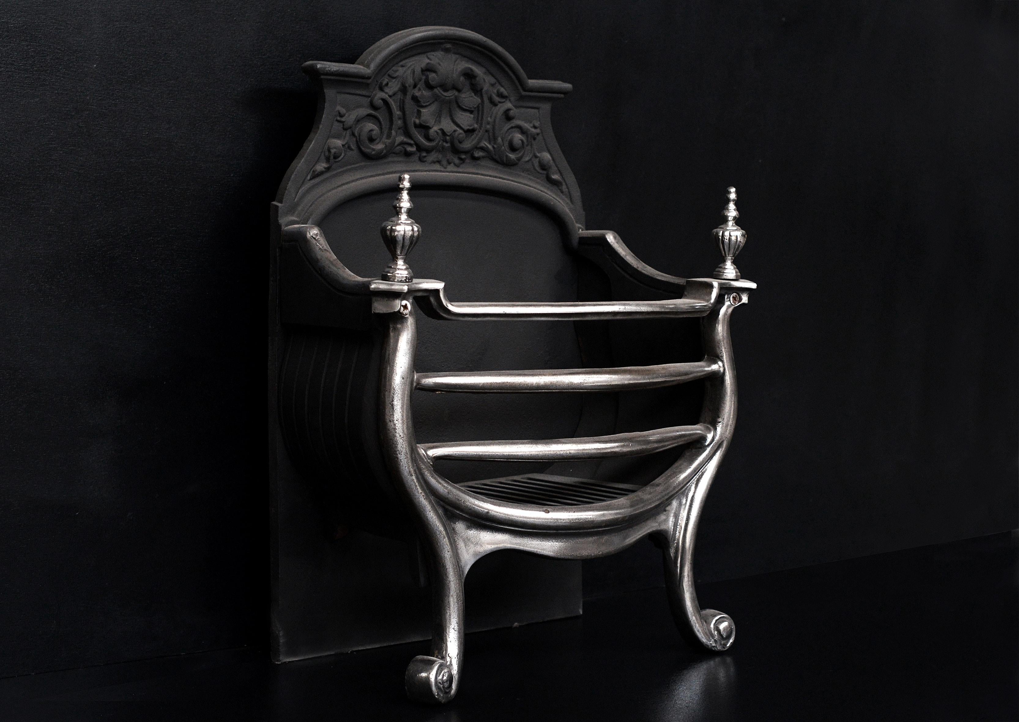 A unassuming yet elegant polished cast iron firebasket. The shaped front with scrolled bases and gadrooned urn finials. Decorative cast back, late 19th century.

Width At Front:	546 mm      	21 ½