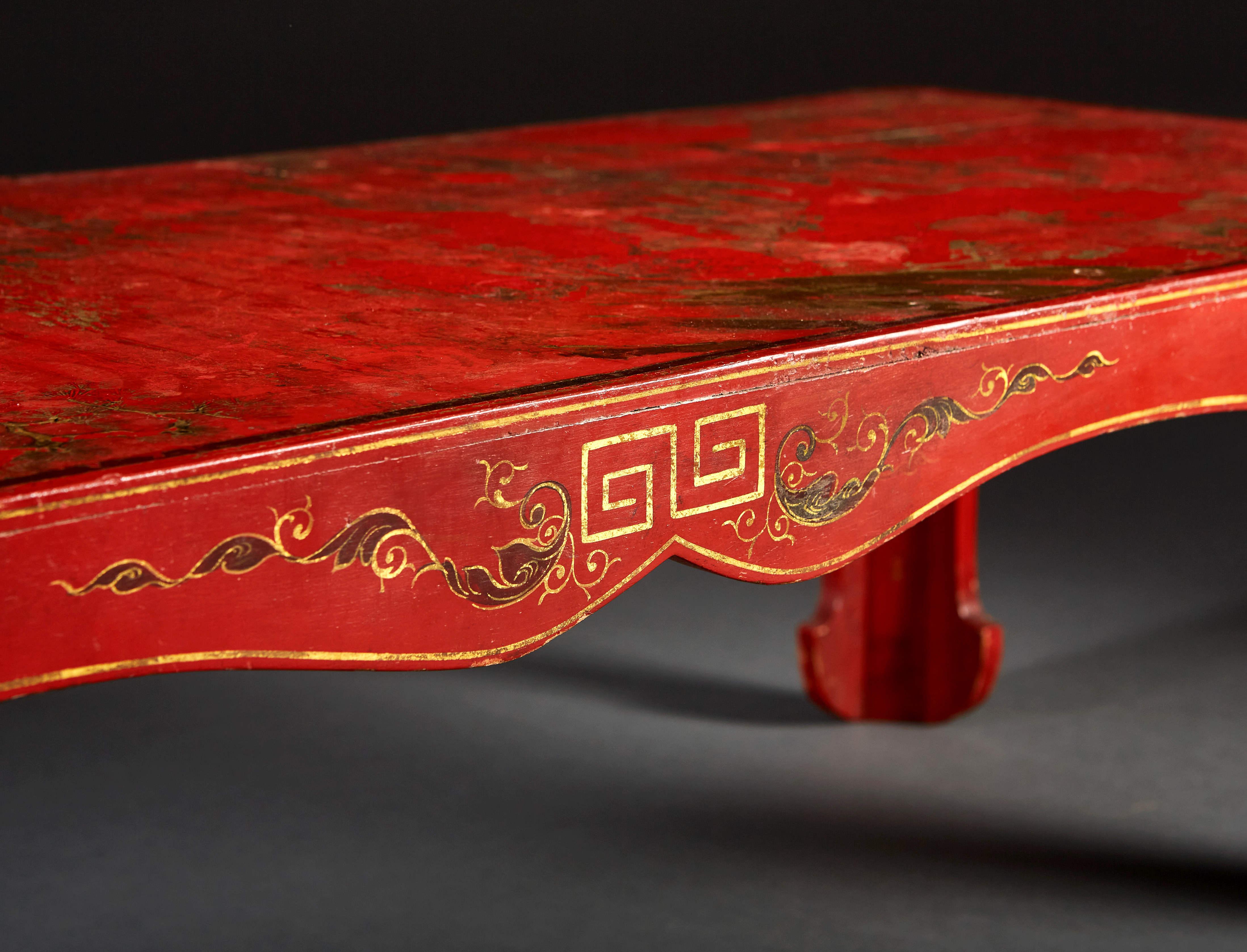 A late nineteenth century red lacquer low table, decorated with pavilions and floral motives.

 