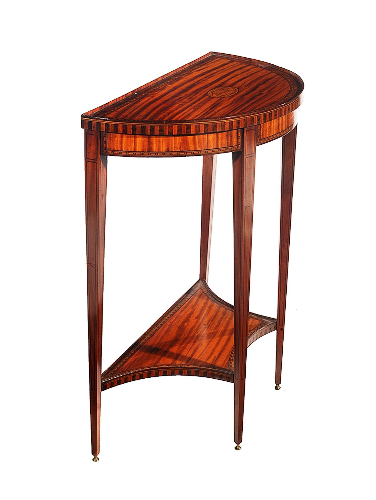 An unusually small demilune satinwood and marqetary console table.
The top with a raised satinwood parqetary gallery and a central satinwood marquetry shell motif
The whole raised on slender square tapering legs that end on small brass feet.