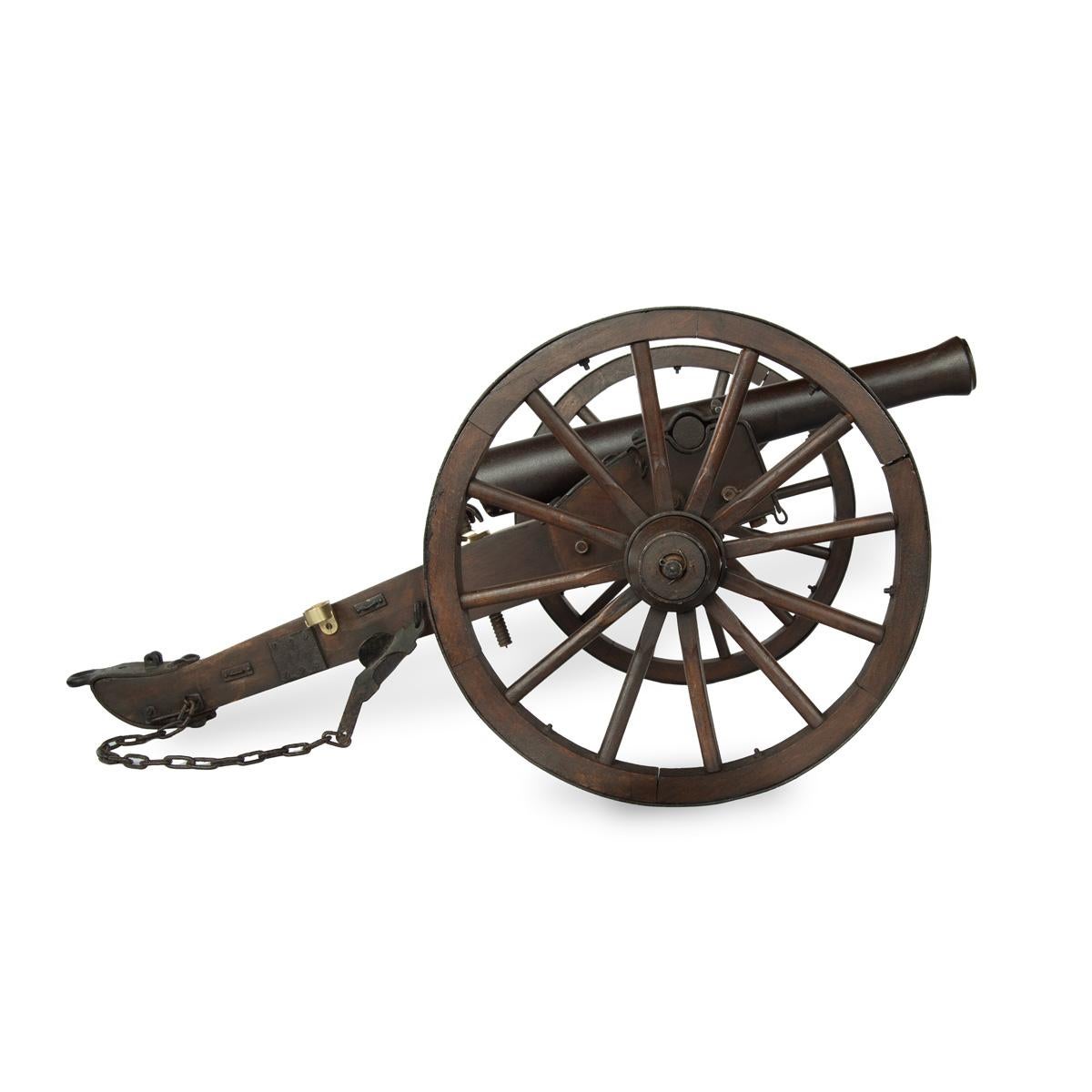 A late 19th century scale model of field cannon, the barrel with a flared muzzle on an oak carriage with twin twelve spoke steel rimmed wheels and steel mounted body, a single ammunition box, chain and various other fittings.  Continental, circa