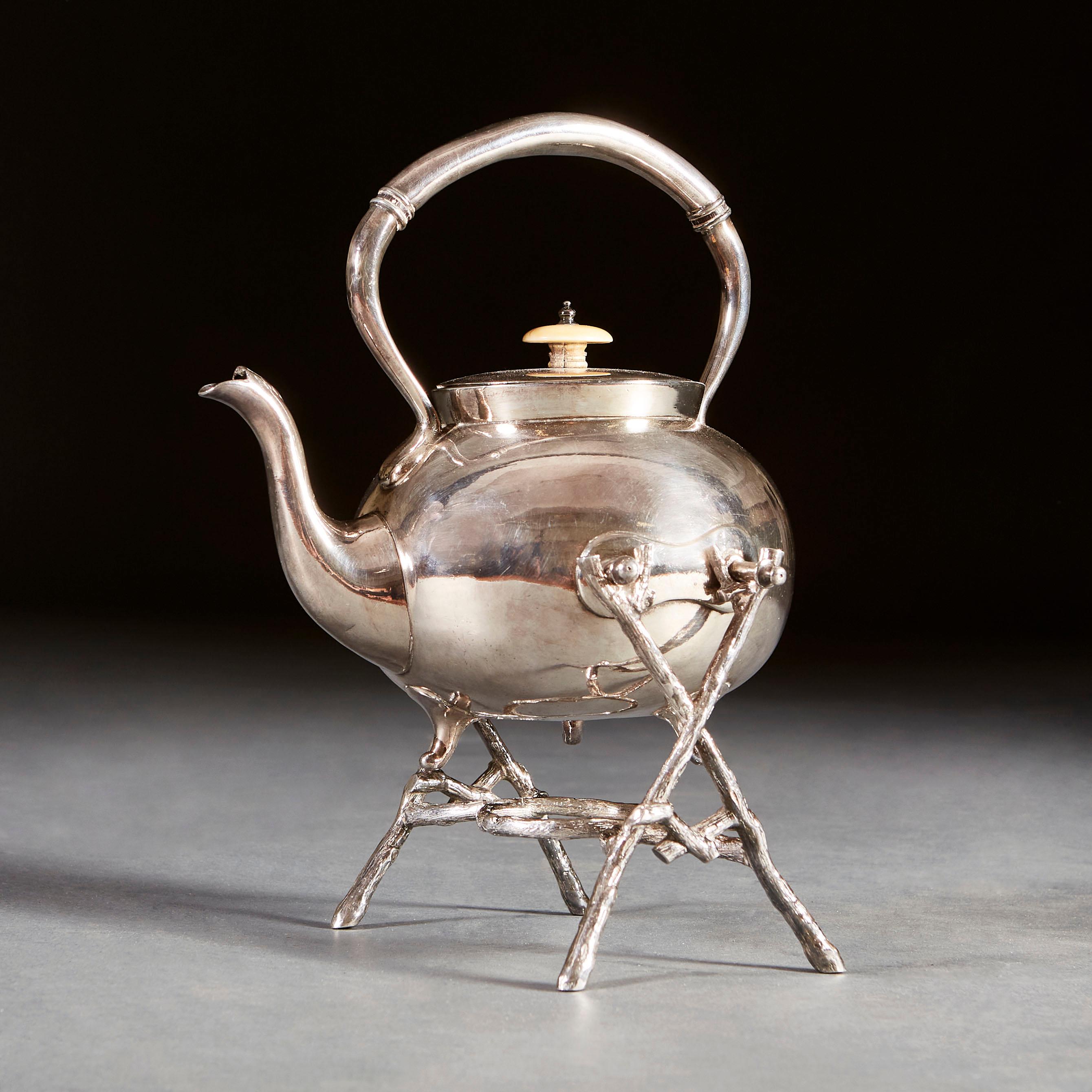 A late nineteenth century silver plated teapot on stand by James Deakin & Sons, with tripod feet and bone handle, the stand with x frame ends.